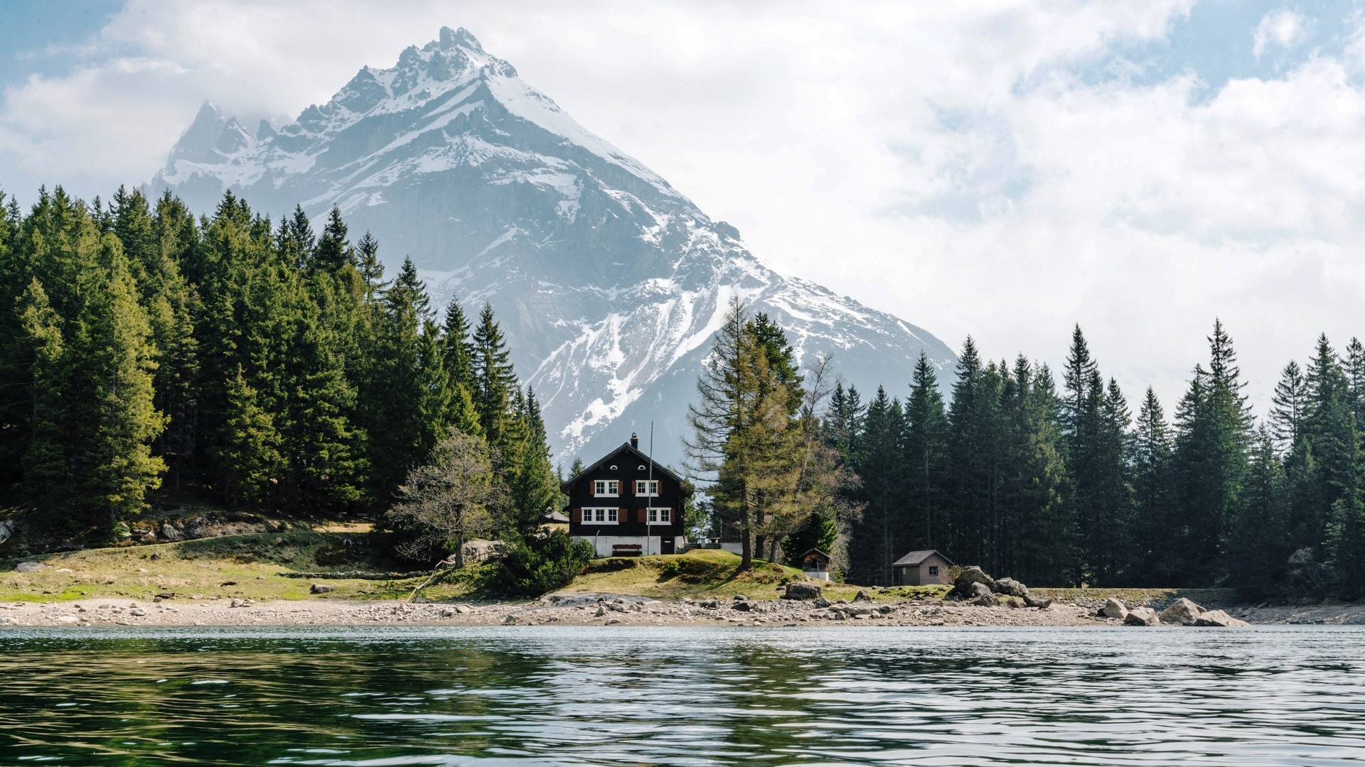 House by a lake with mountains and trees HD Wallpaper