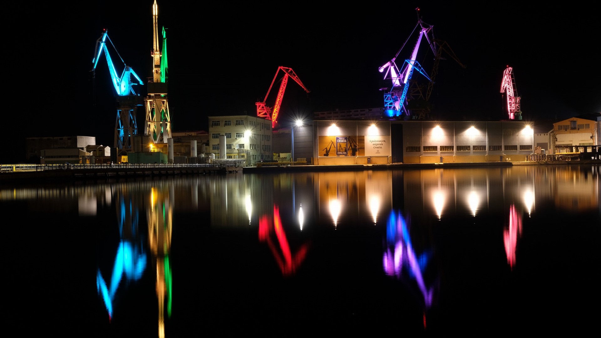 Night view of illuminated harbor cranes in Pula, Croatia HD Wallpaper