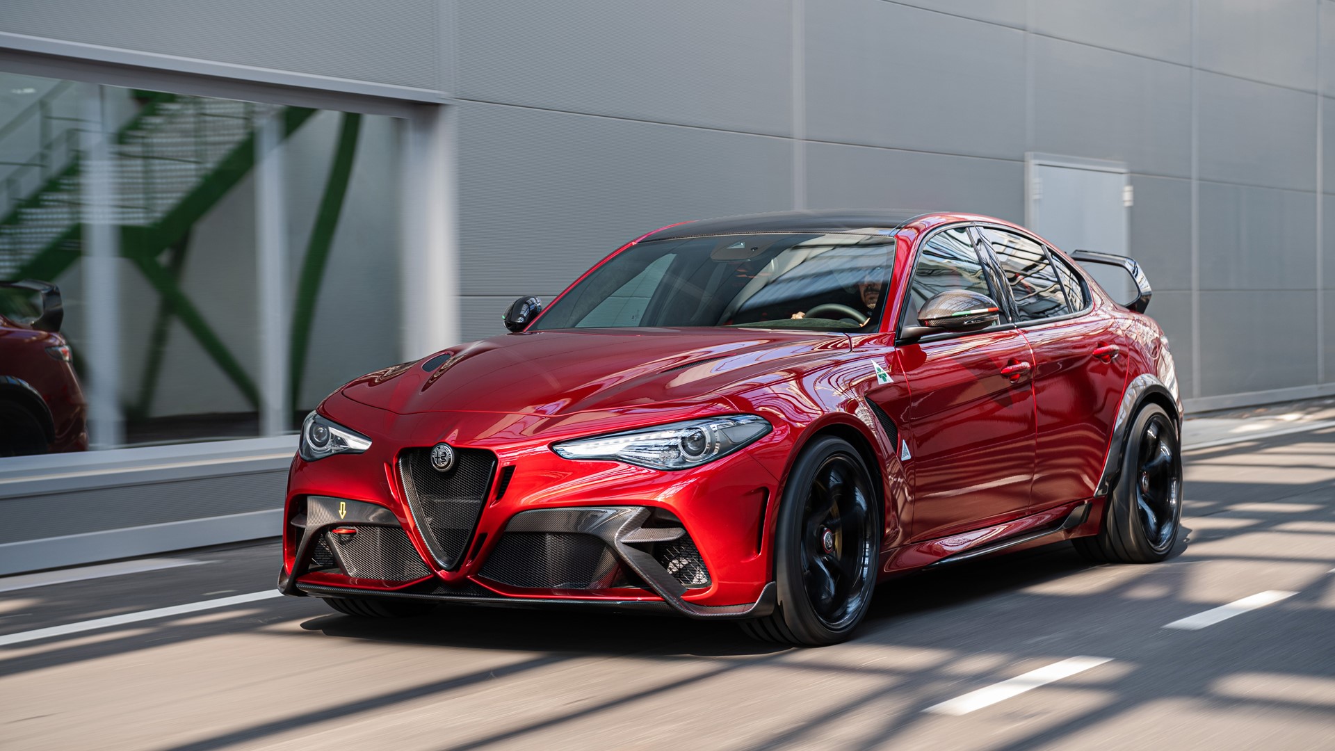 Red Alfa Romeo Giulia Quadrifoglio driving on road HD Wallpaper