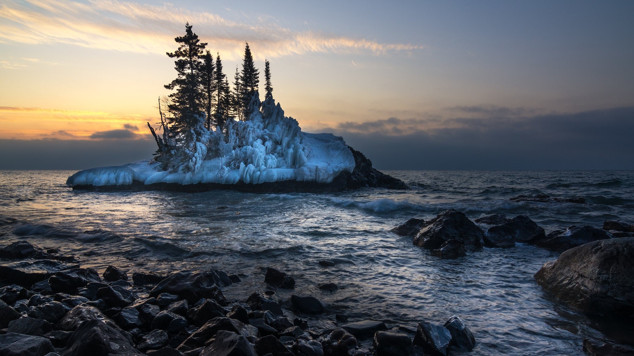Frozen island with trees on a lake at sunrise HD Wallpaper