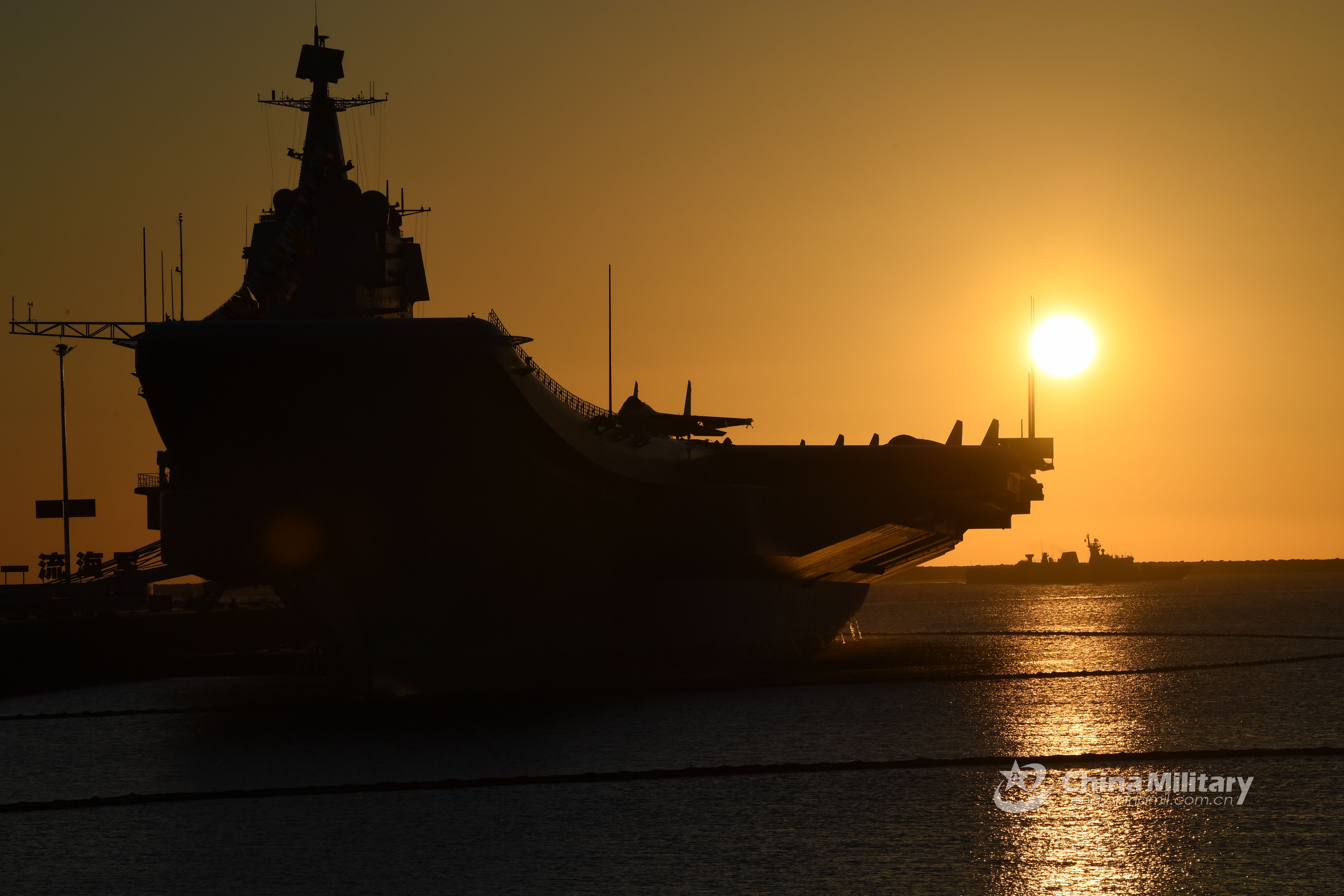 Aircraft carrier silhouetted against the sun HD Wallpaper