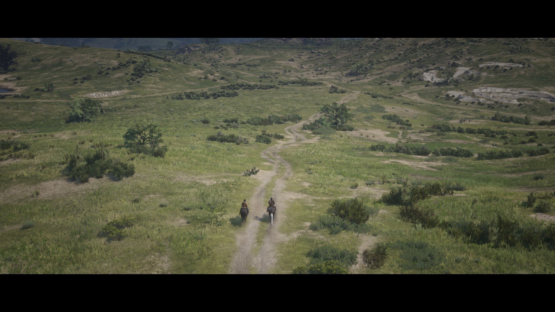 Two people on horseback on a dirt road in Red Dead Redemption 2 HD Wallpaper