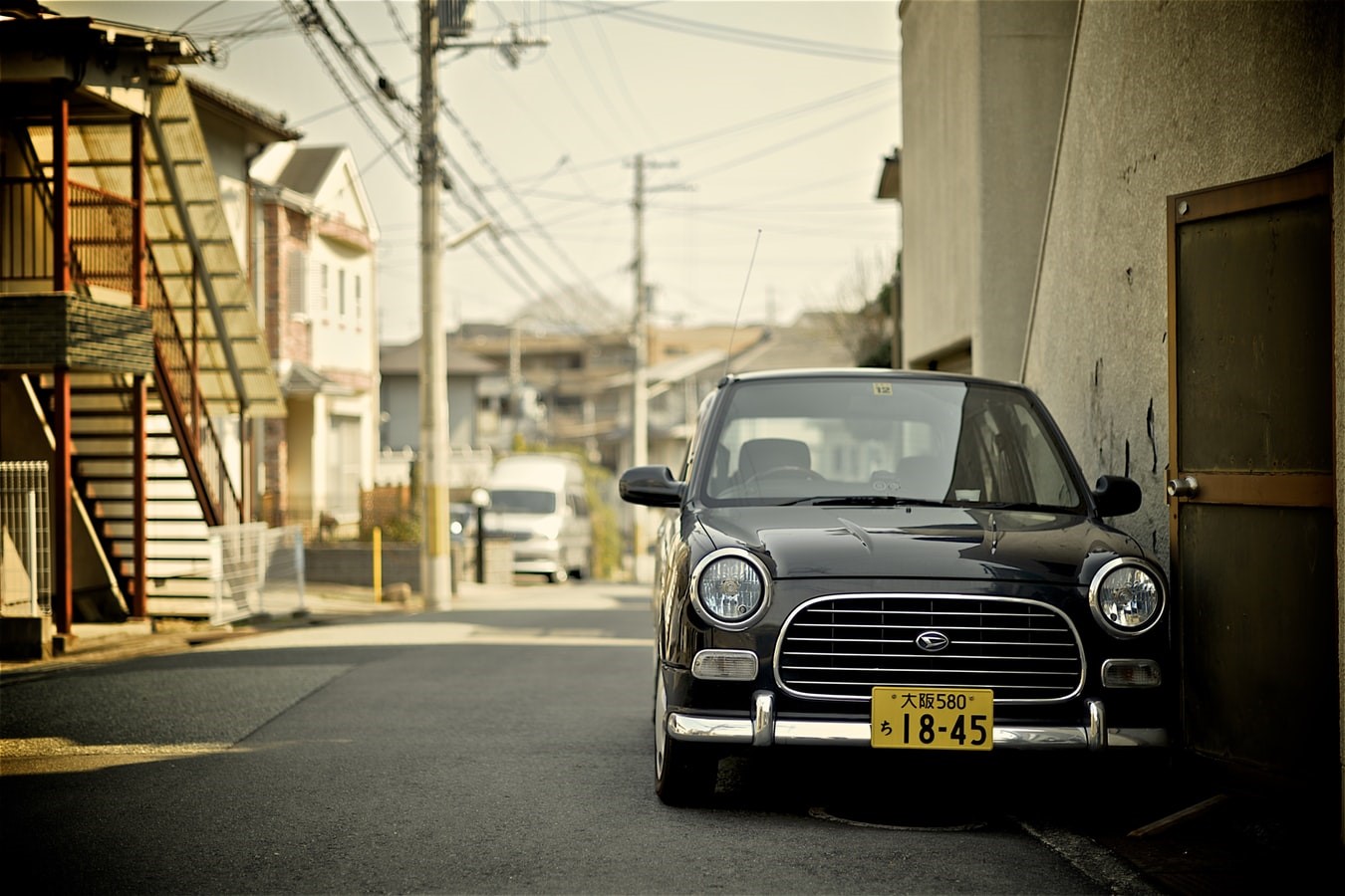Black Daihatsu Mira Gino parked on a street in Osaka, Japan HD Wallpaper