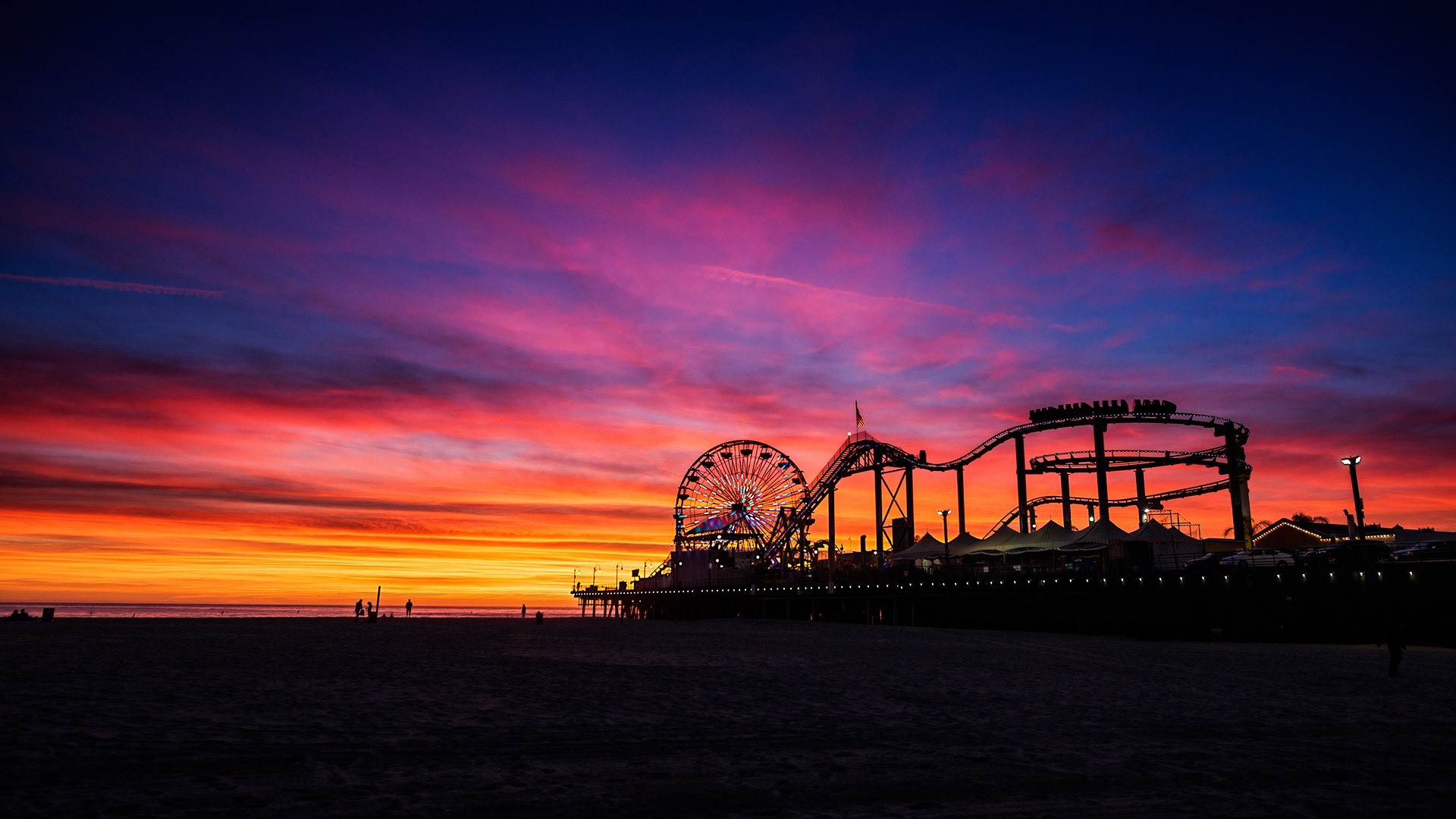 Theme park with Ferris wheel and roller coaster at sunset HD Wallpaper
