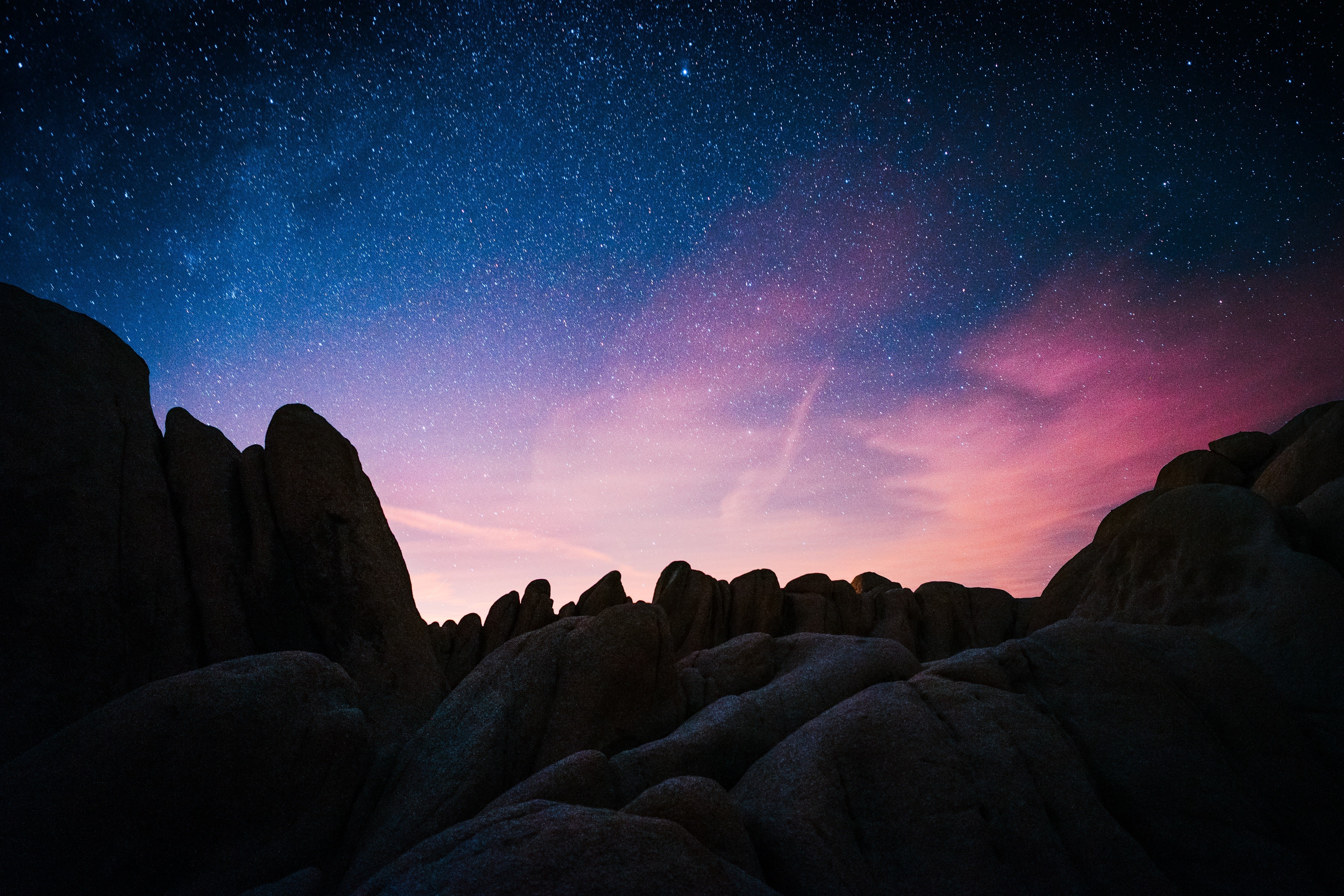 Starry night sky over rocky landscape HD Wallpaper