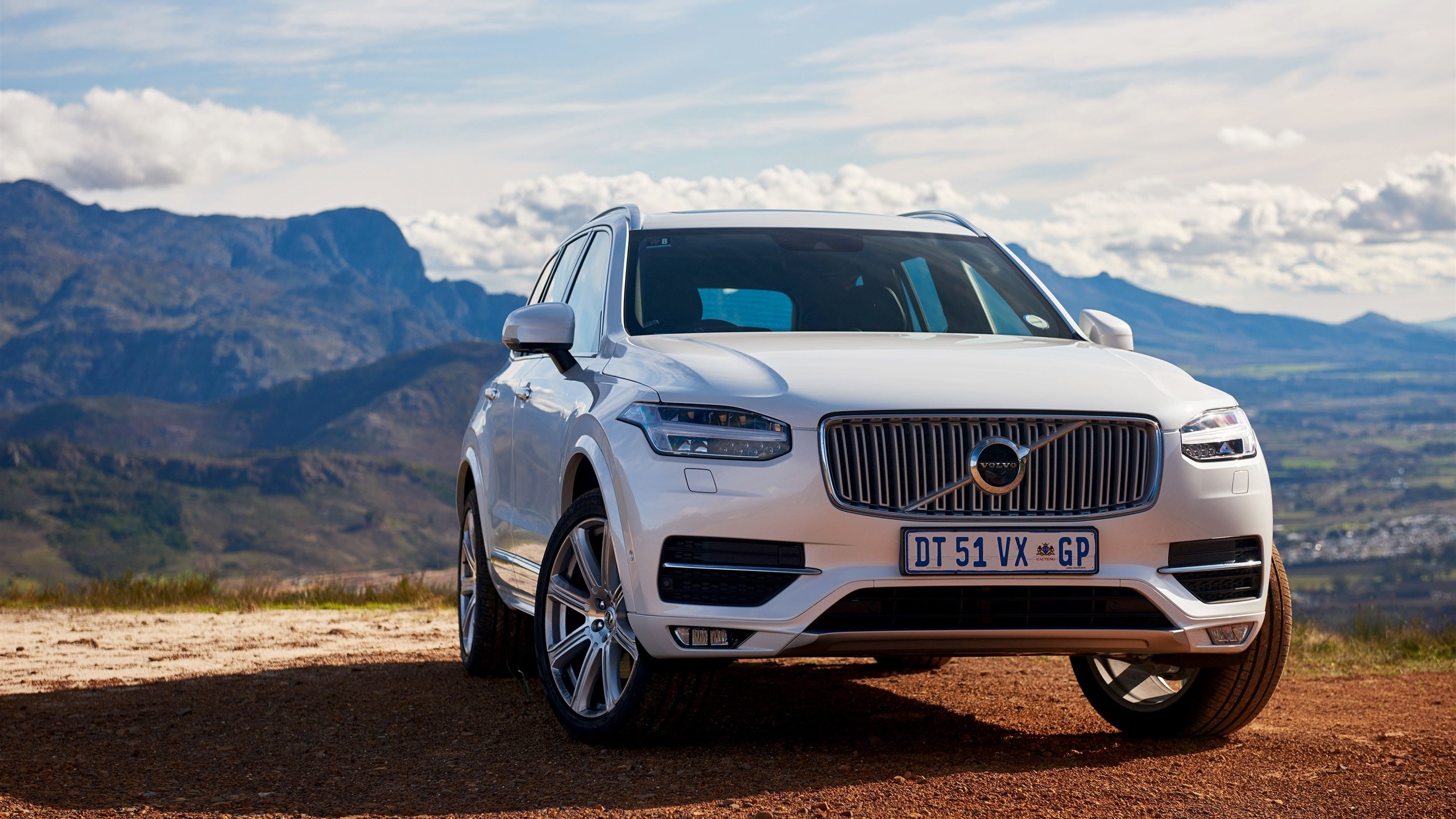 White Volvo XC90 SUV parked on a dirt road with mountains HD Wallpaper