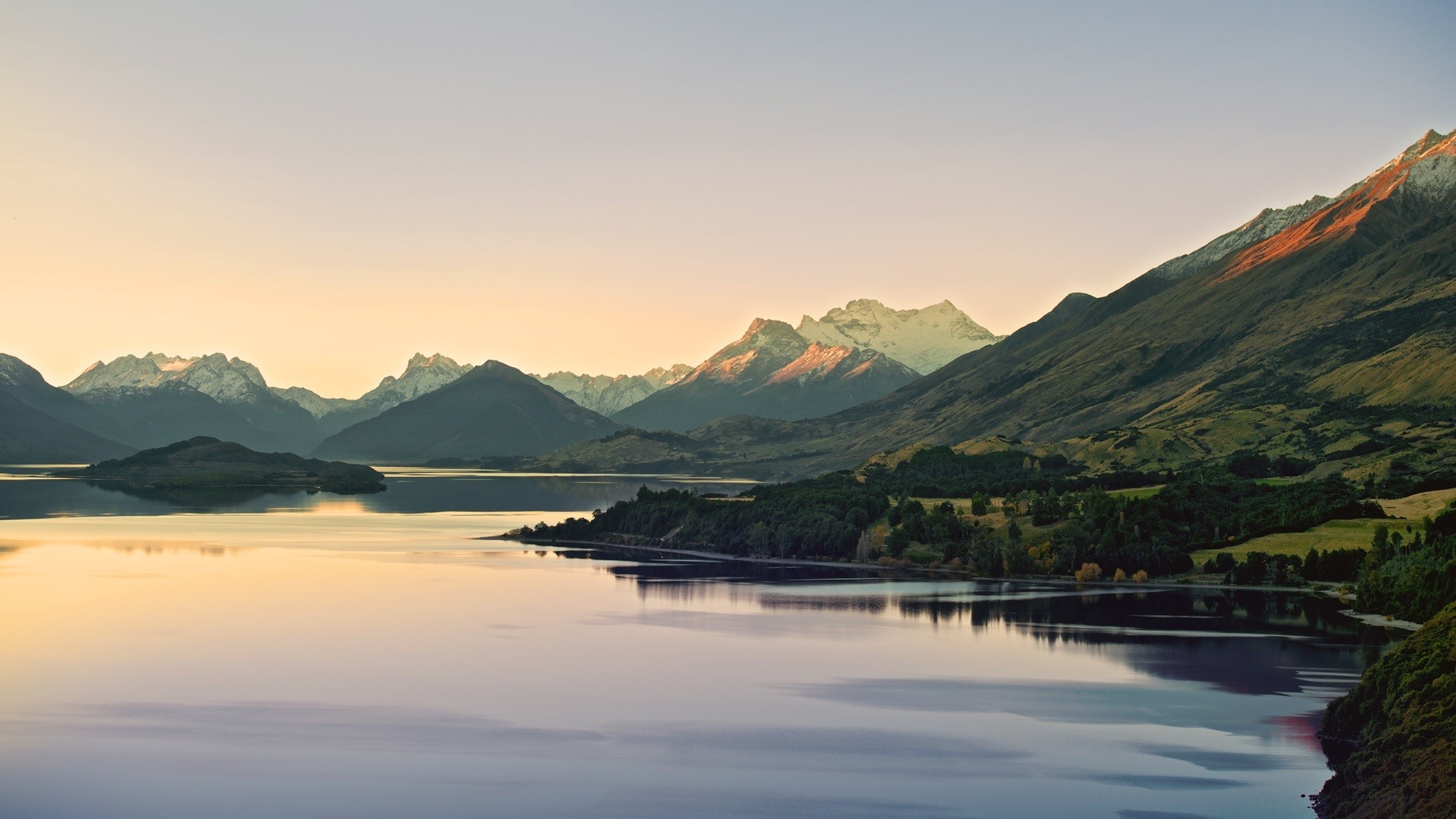 Mountain range reflected in a calm lake at dusk HD Wallpaper