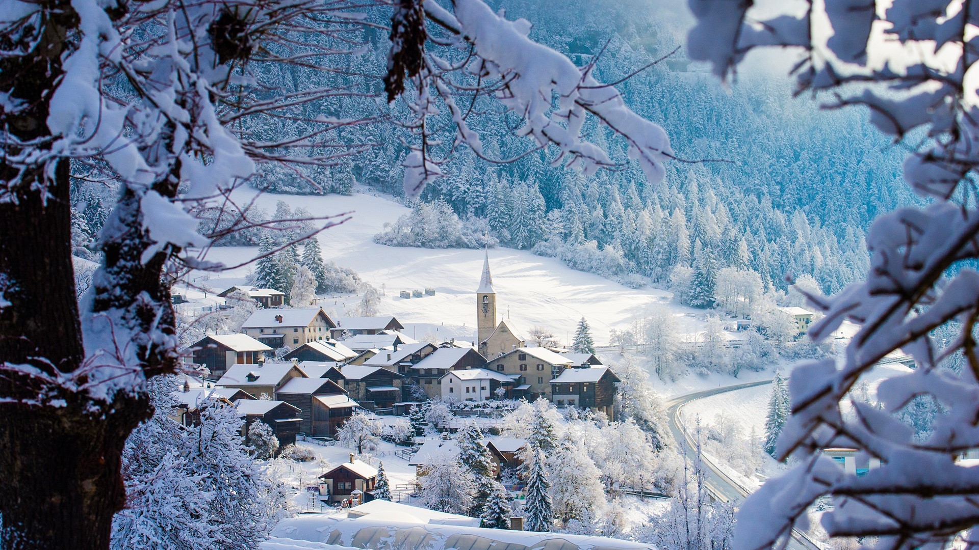 Snowy village with church in a mountain landscape HD Wallpaper