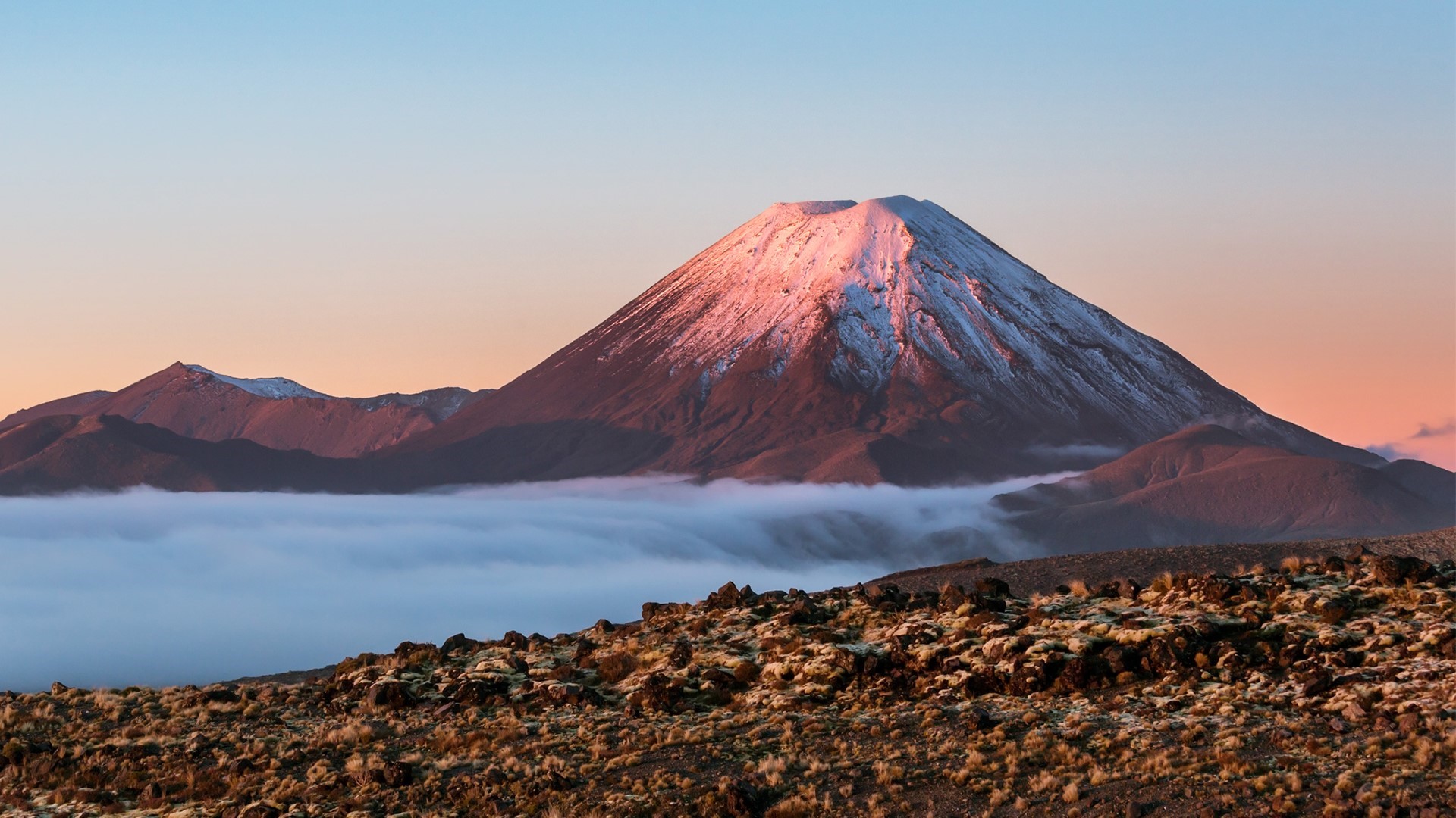 Mount Ngauruhoe volcano with snowy peak over clouds HD Wallpaper