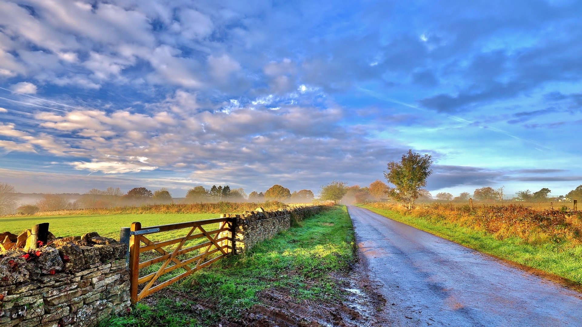 Country road with stone wall and wooden gate HD Wallpaper