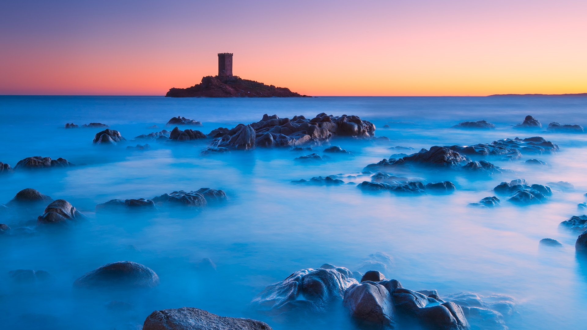 Rocky coastline with tower at sunset, long exposure HD Wallpaper