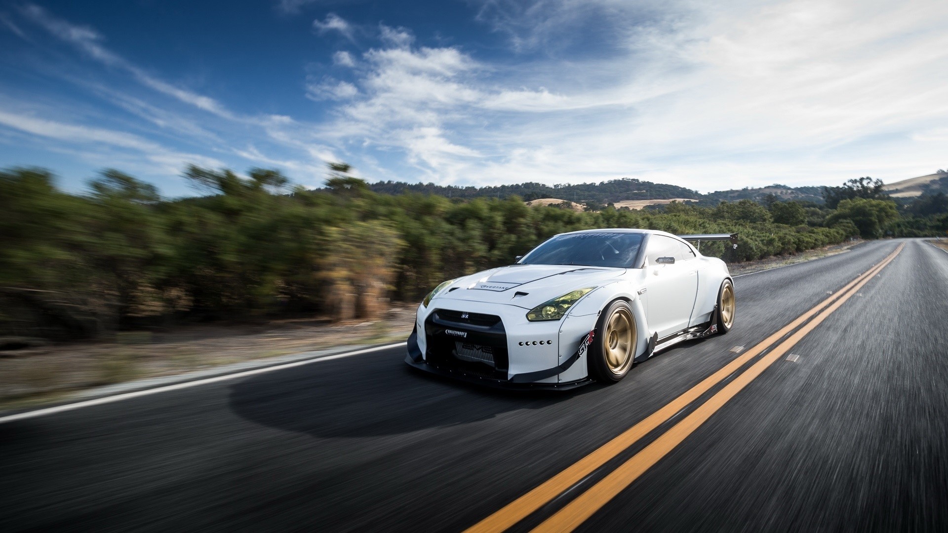 White Nissan GT-R driving on a scenic road HD Wallpaper