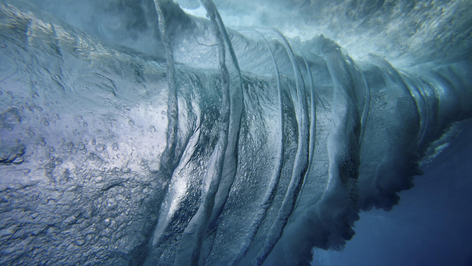 Underwater view of a breaking wave with bubbles HD Wallpaper