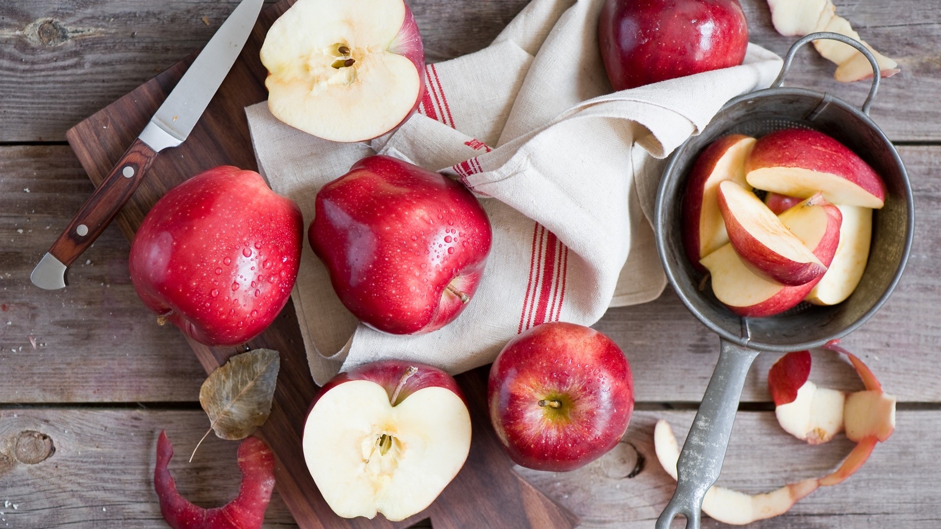 Red apples on a wooden table with a knife and cutting board HD Wallpaper