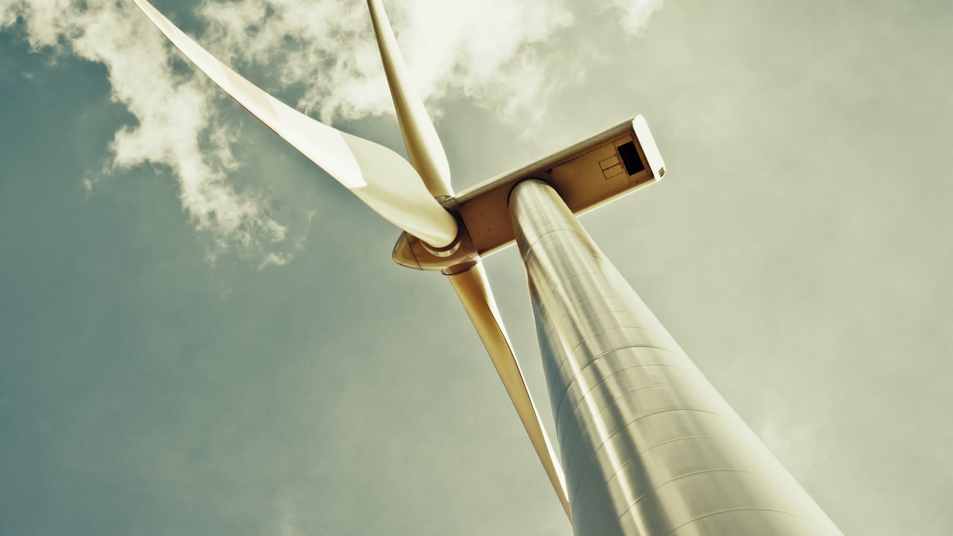 Wind turbine against a cloudy sky HD Wallpaper