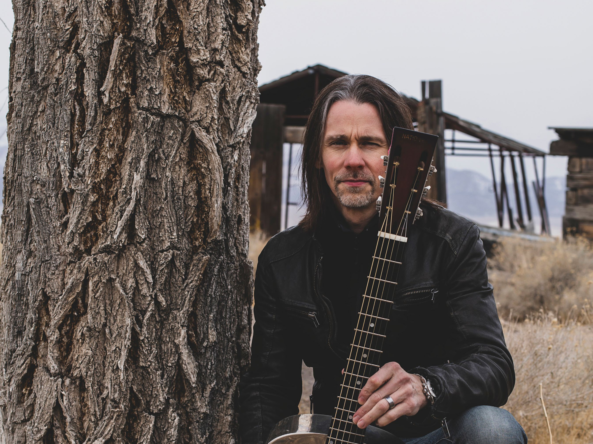Myles Kennedy with guitar in front of abandoned building HD Wallpaper