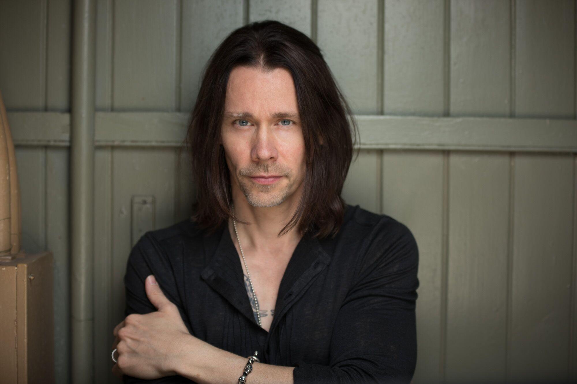 Myles Kennedy poses in front of a wooden wall HD Wallpaper