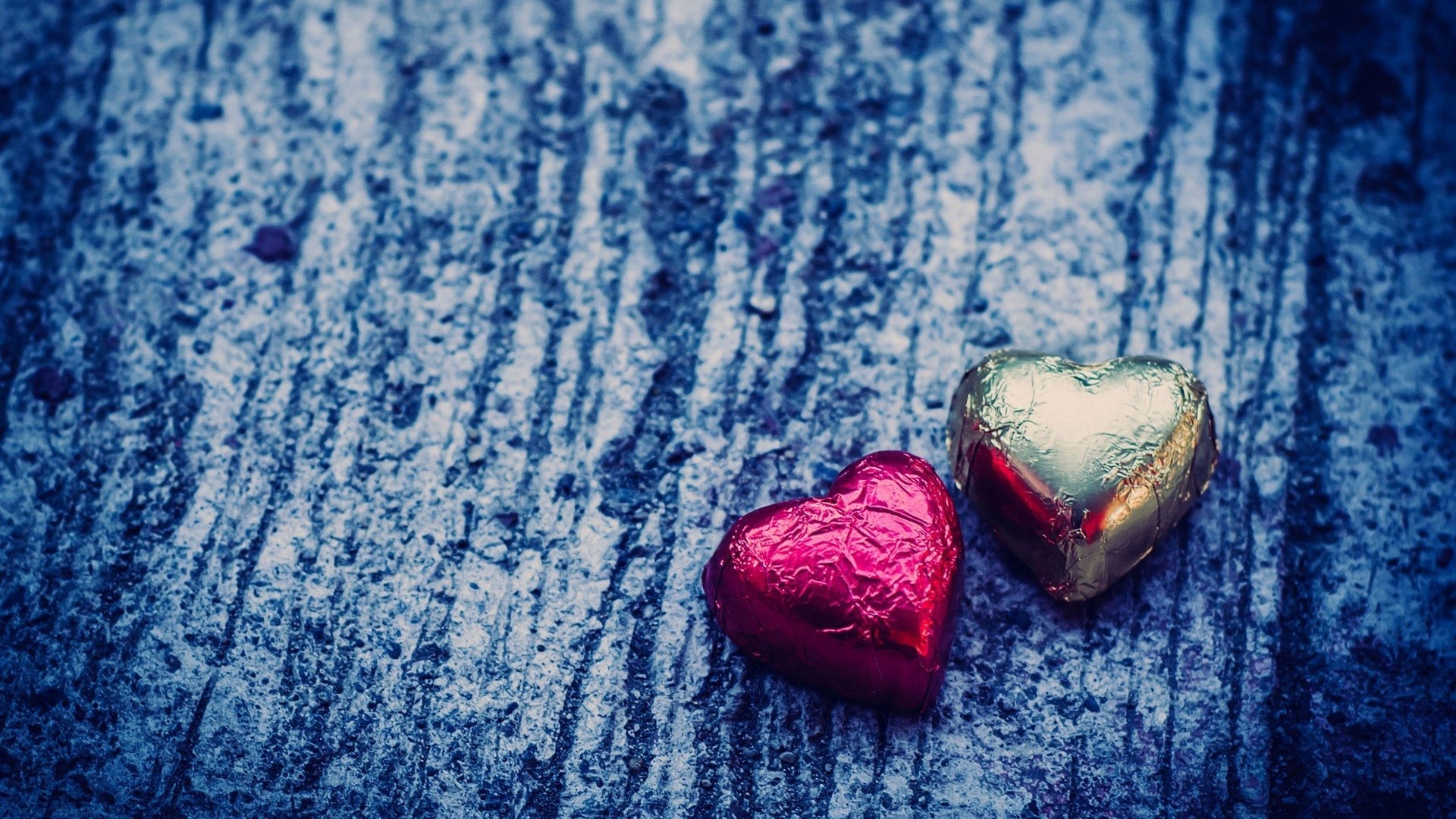 Heart-shaped chocolates on a textured surface HD Wallpaper