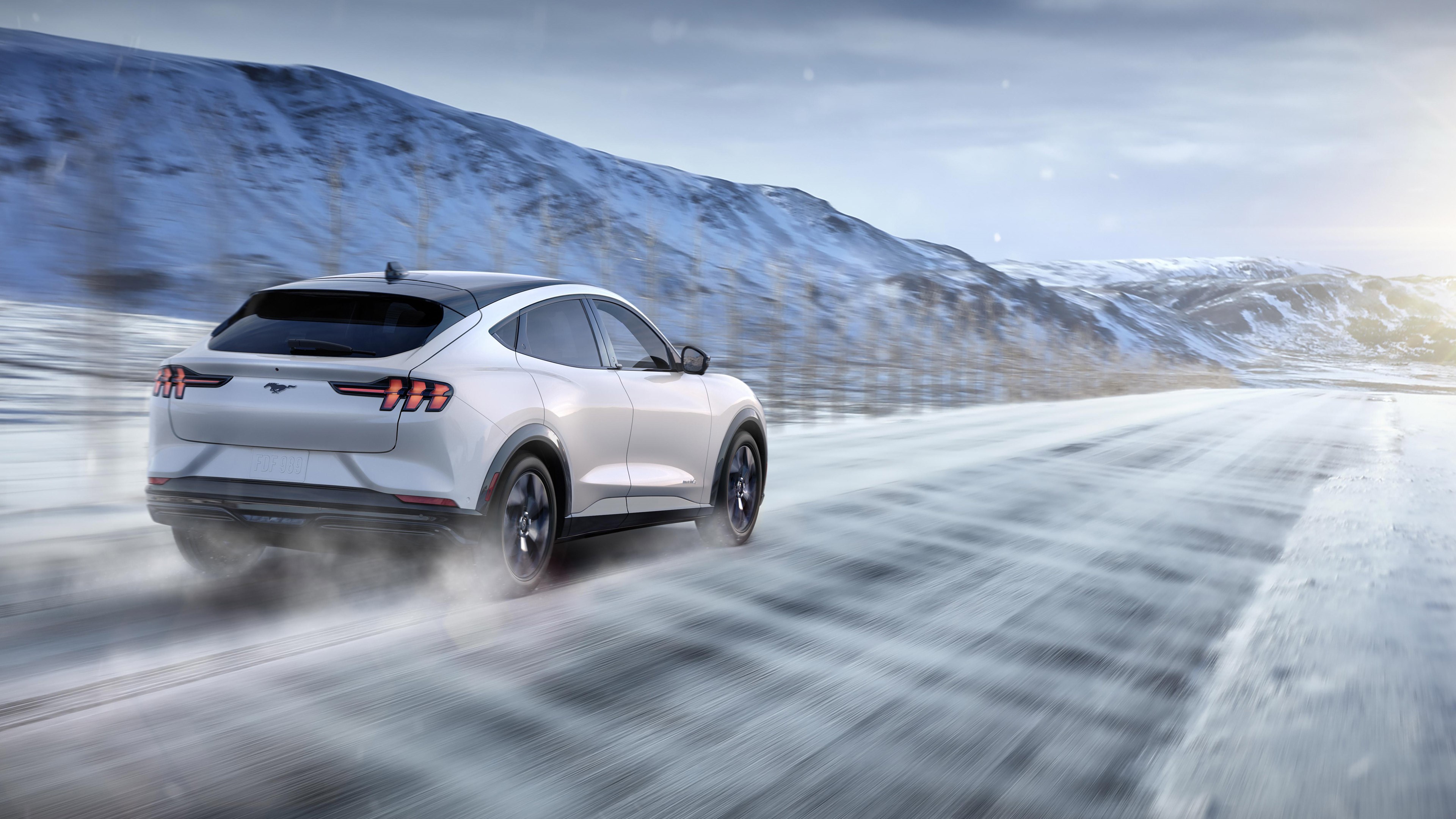 Ford Mustang Mach-E driving on a snowy road HD Wallpaper