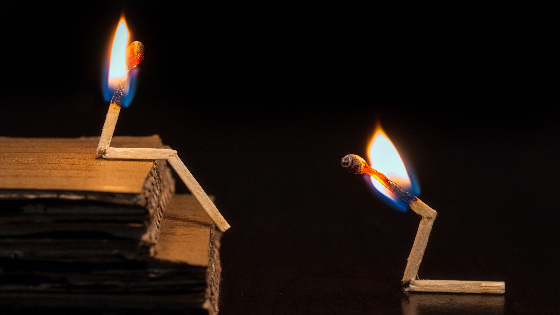 Two burning matchsticks on a dark background HD Wallpaper
