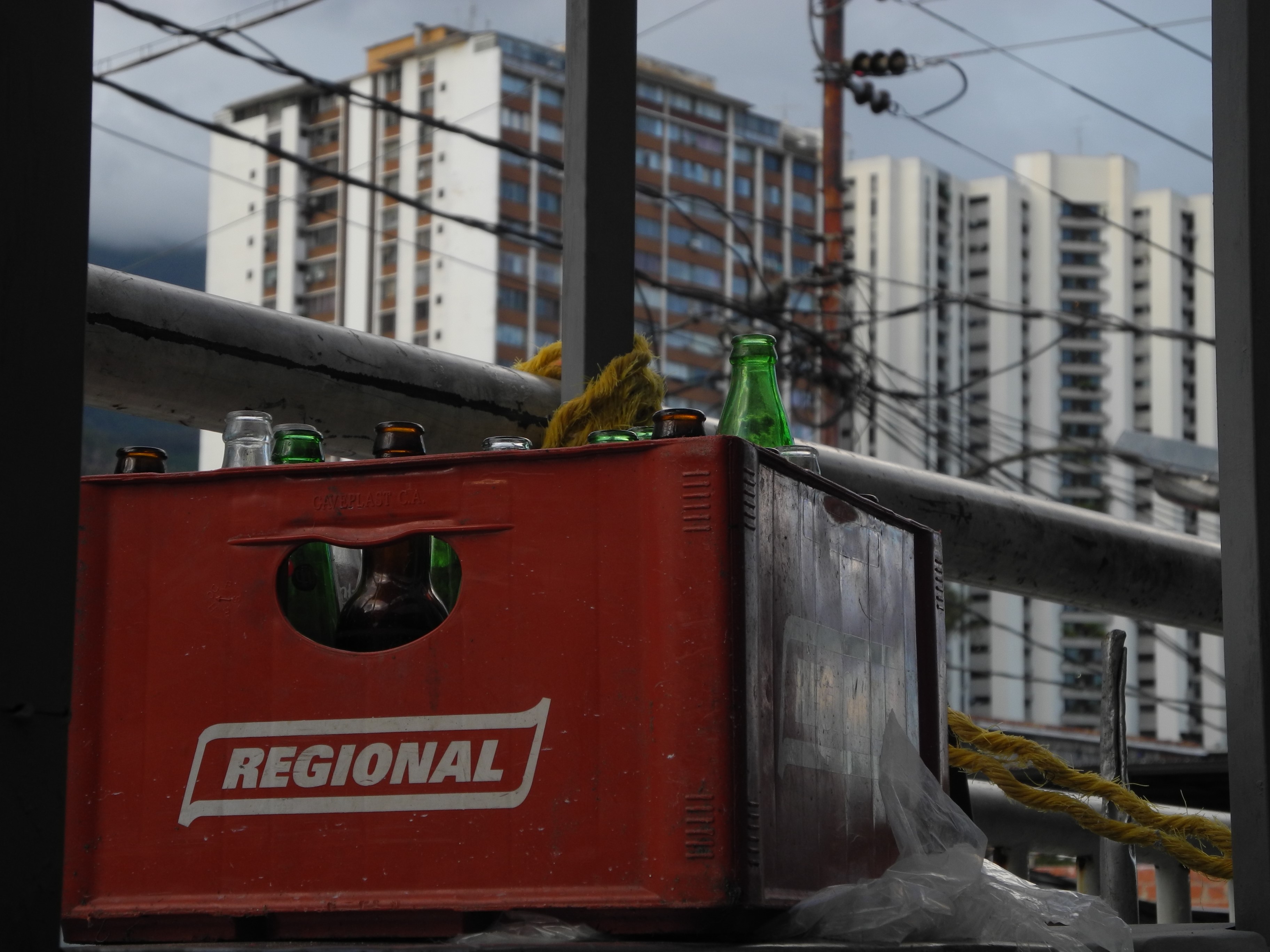 Red crate with bottles and buildings HD Wallpaper