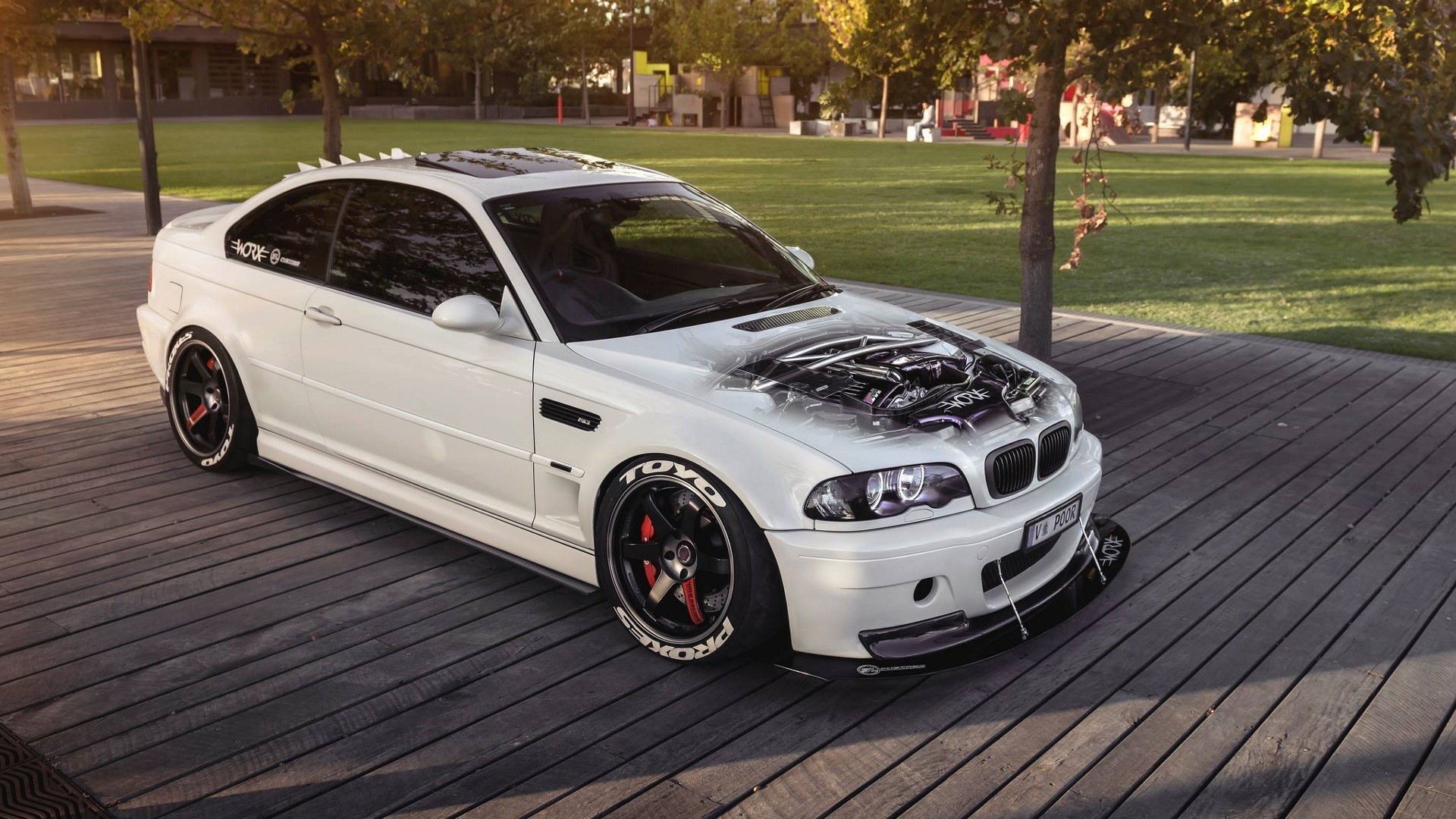 White BMW M3 with custom hood art on wooden deck HD Wallpaper