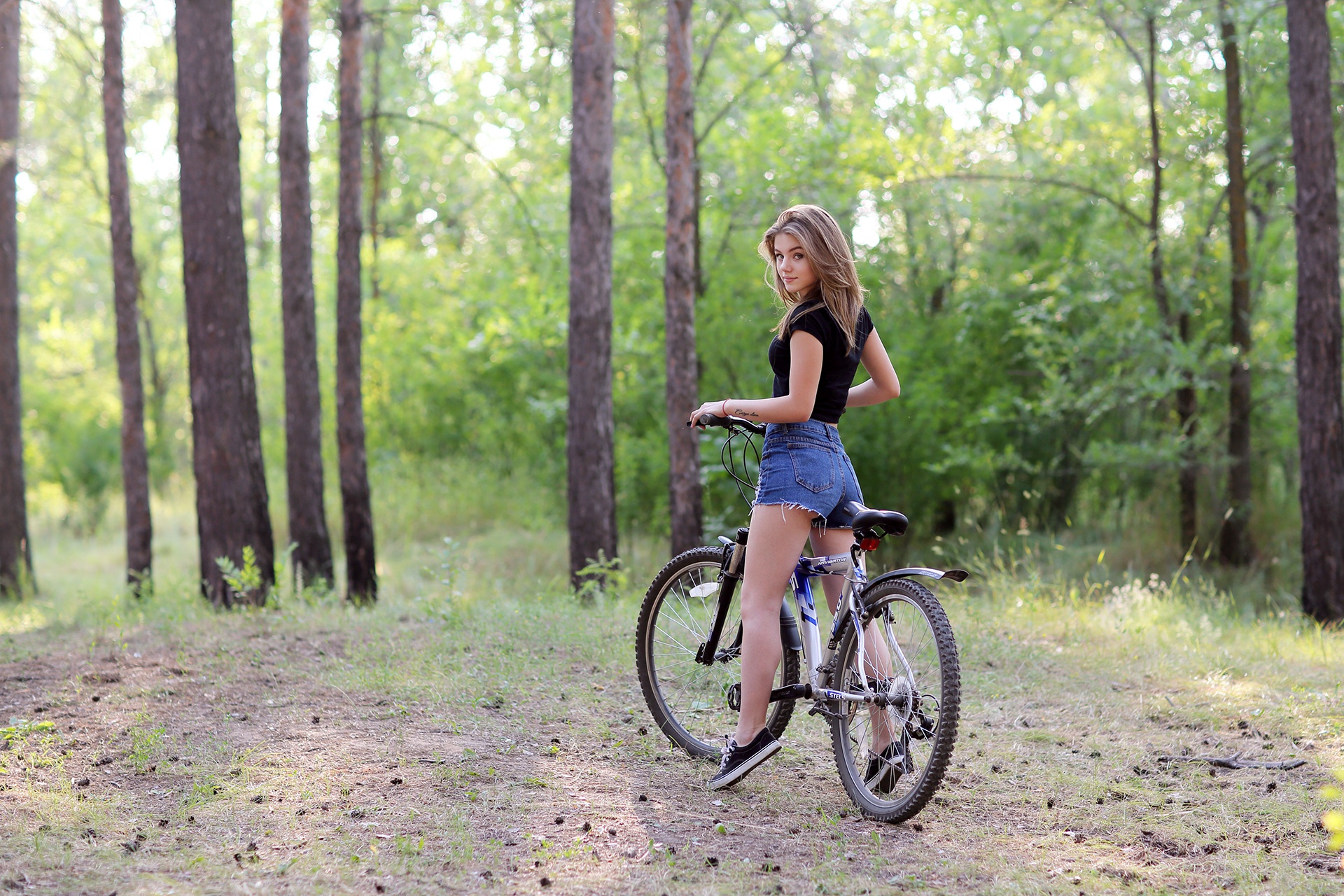Young woman with a bicycle in a forest HD Wallpaper