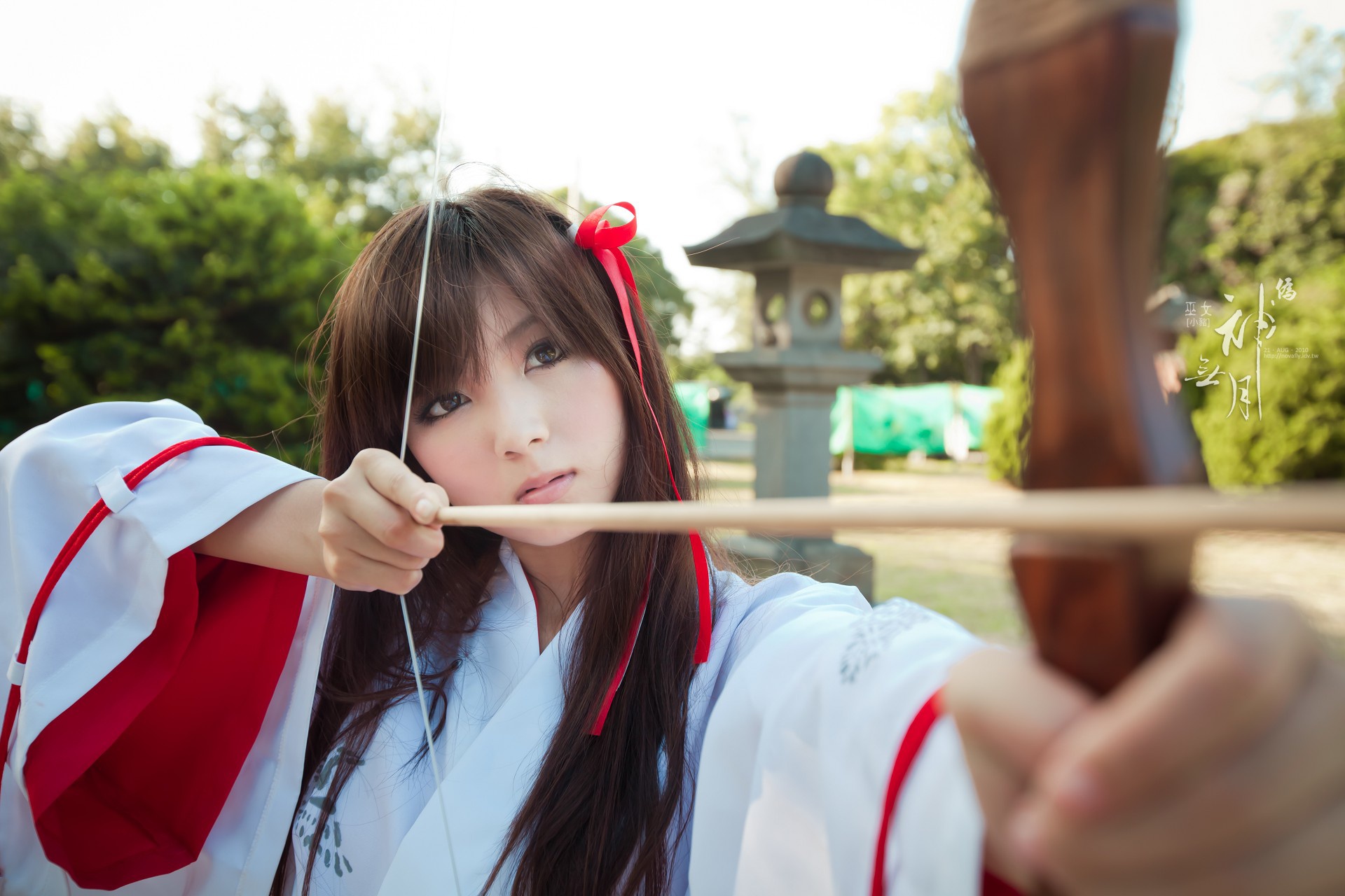 Asian girl in traditional Japanese attire aiming a bow and arrow HD Wallpaper