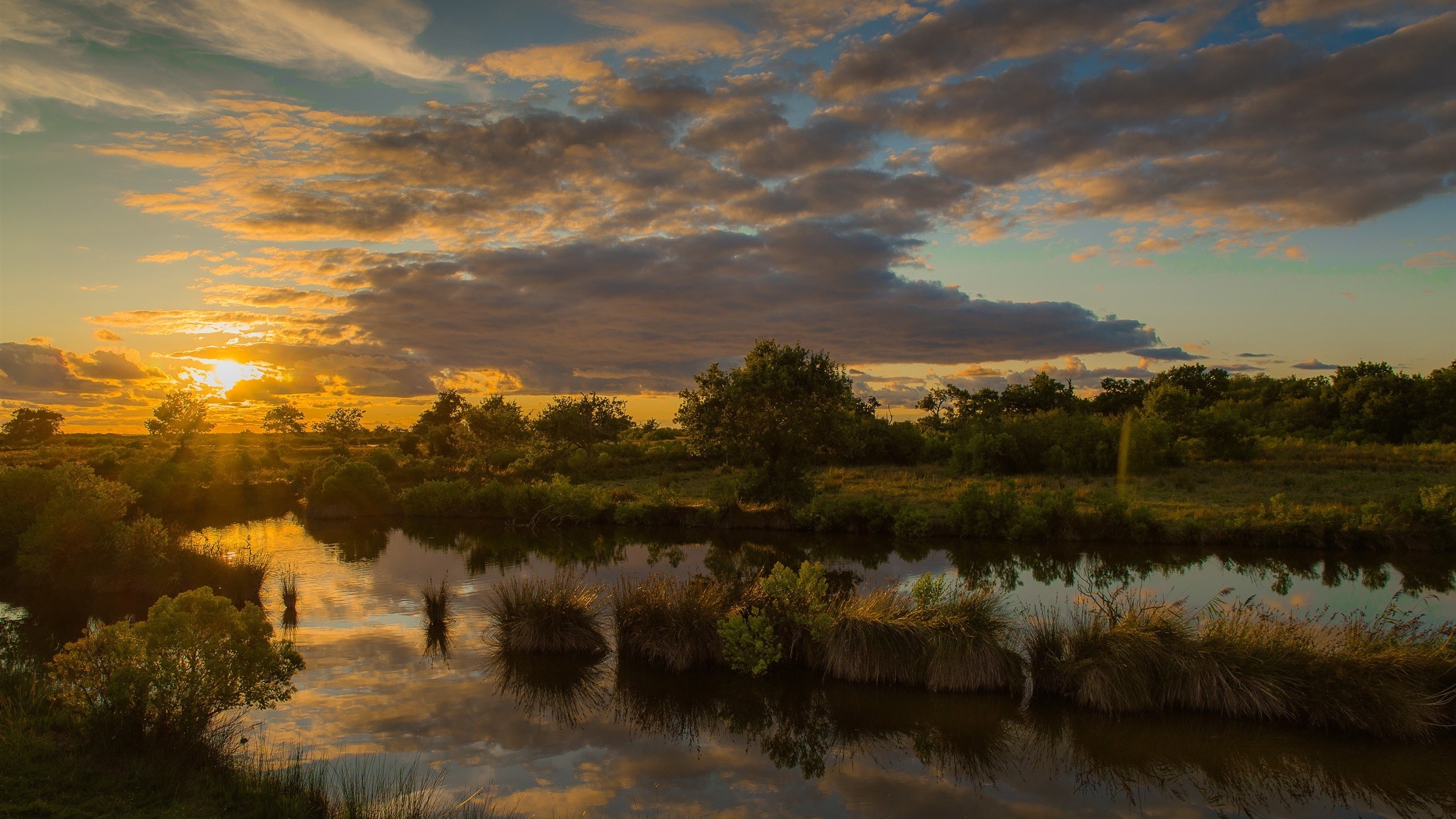 Sunset over a tranquil river landscape with clouds HD Wallpaper