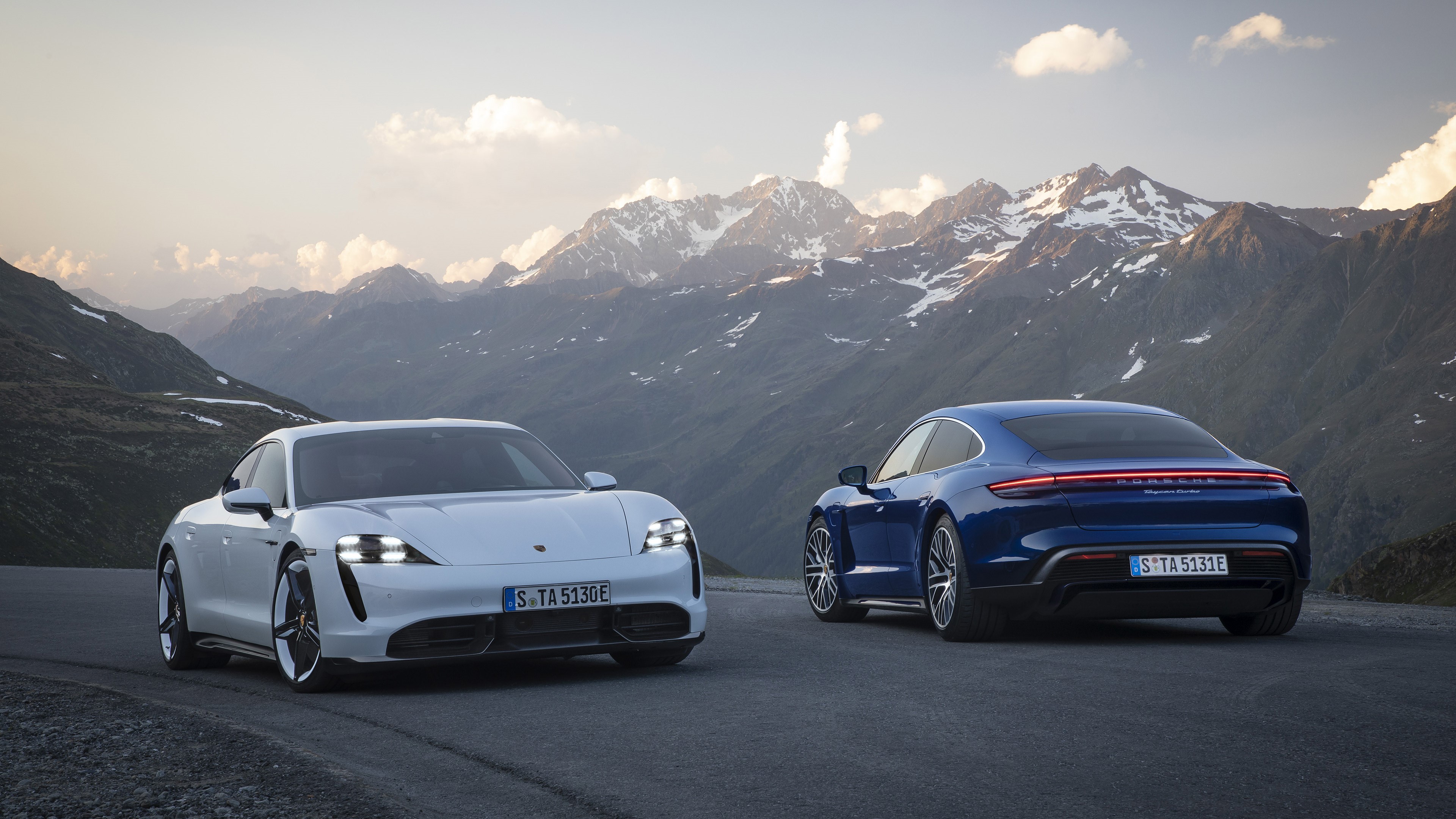 4K Porsche Taycan cars on mountain road HD Wallpaper