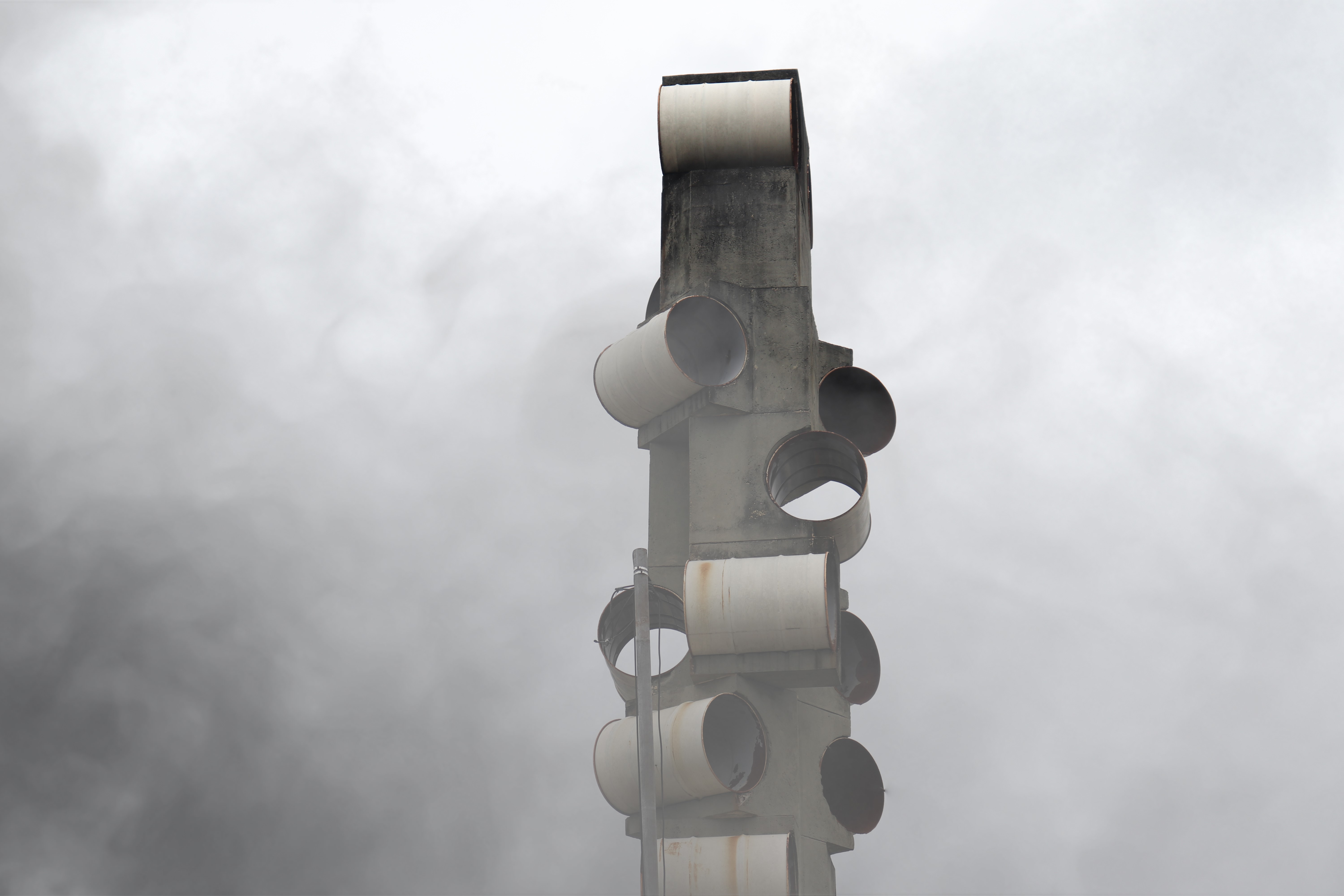 Concrete structure with pipes against cloudy sky HD Wallpaper