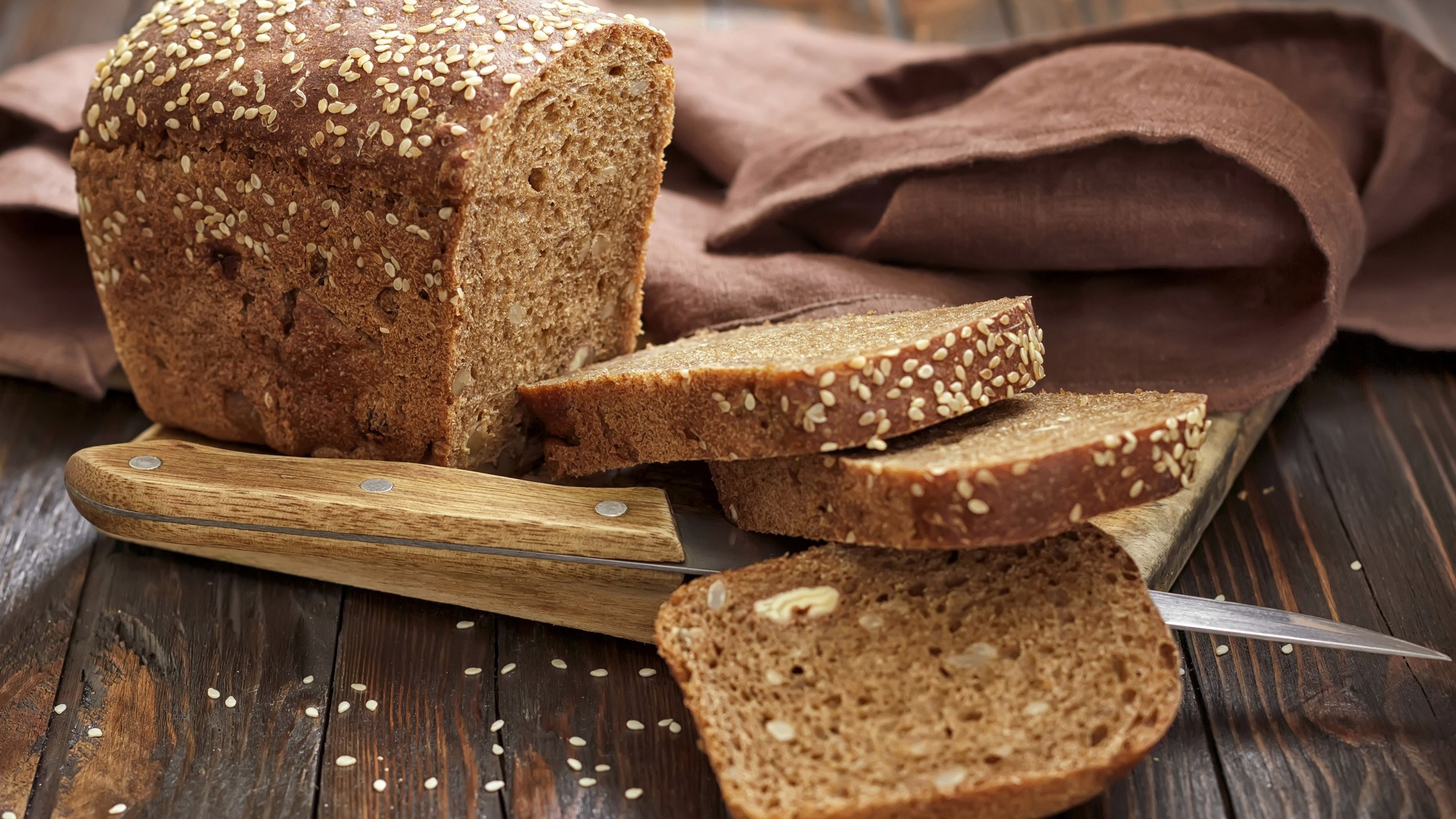 Loaf of bread with slices on a cutting board HD Wallpaper