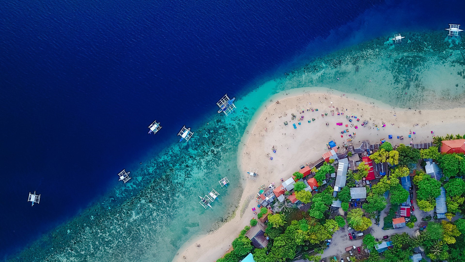 Aerial view of a tropical island with boats and beach HD Wallpaper
