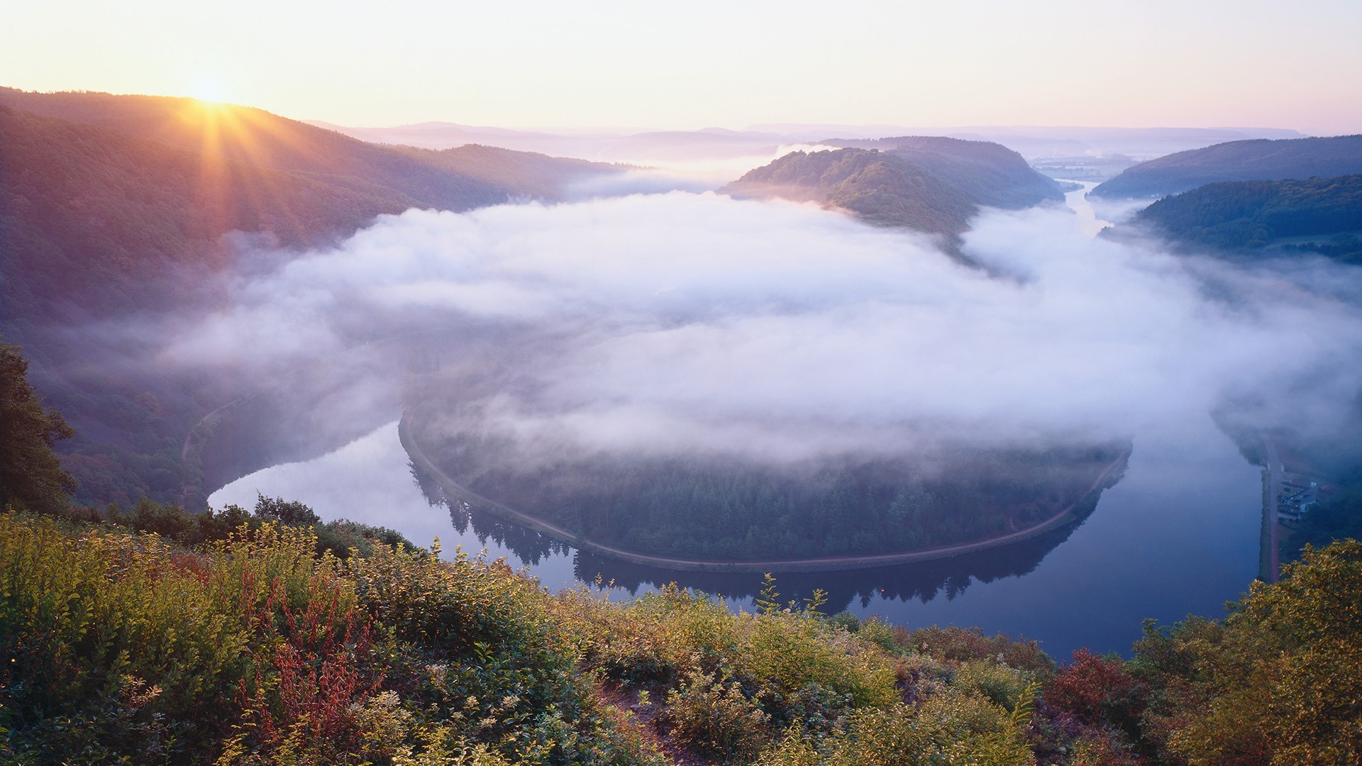 Misty river valley at sunrise with sun rays over mountains HD Wallpaper