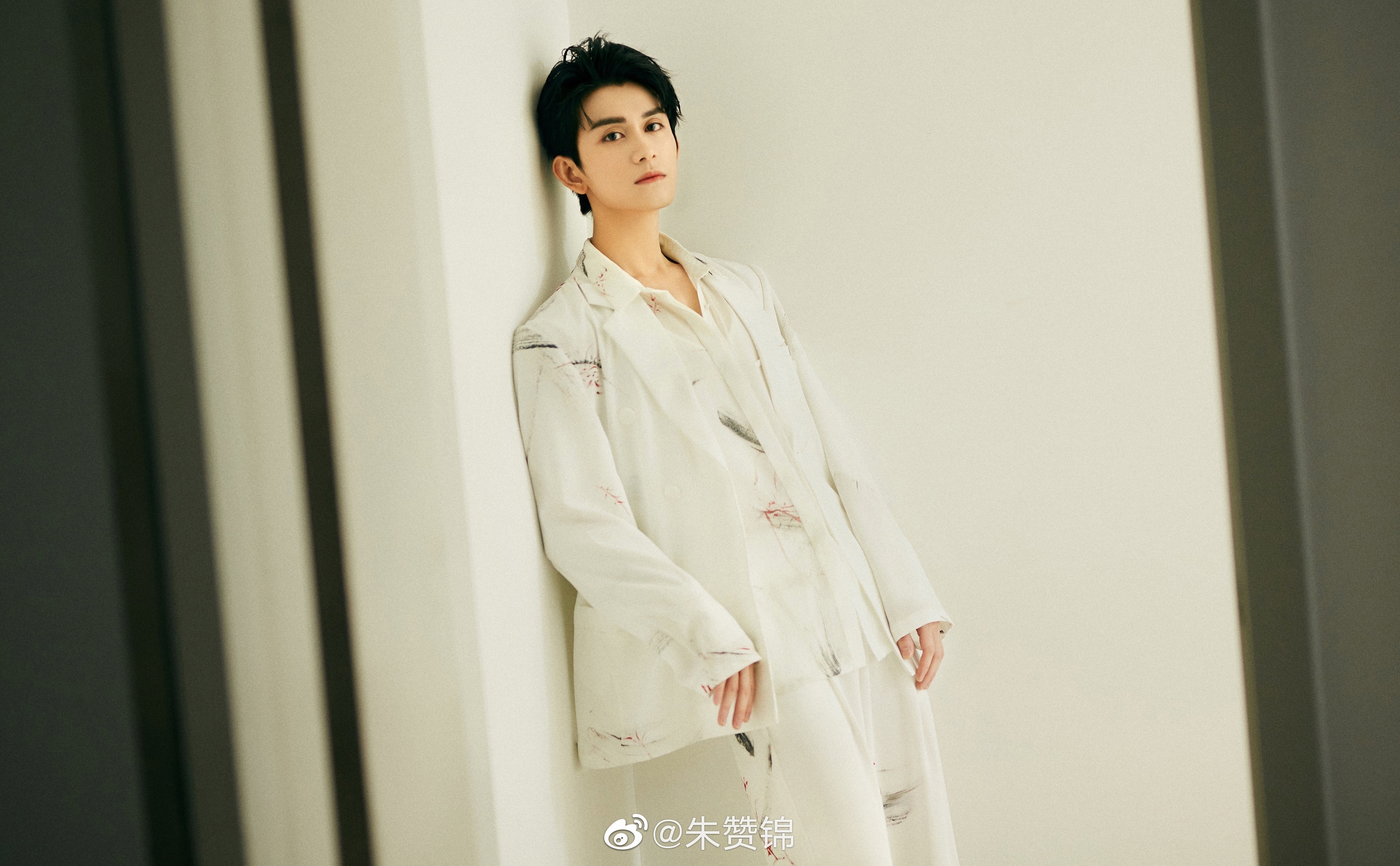 Zhu Zanjin leans against a wall in a white suit HD Wallpaper