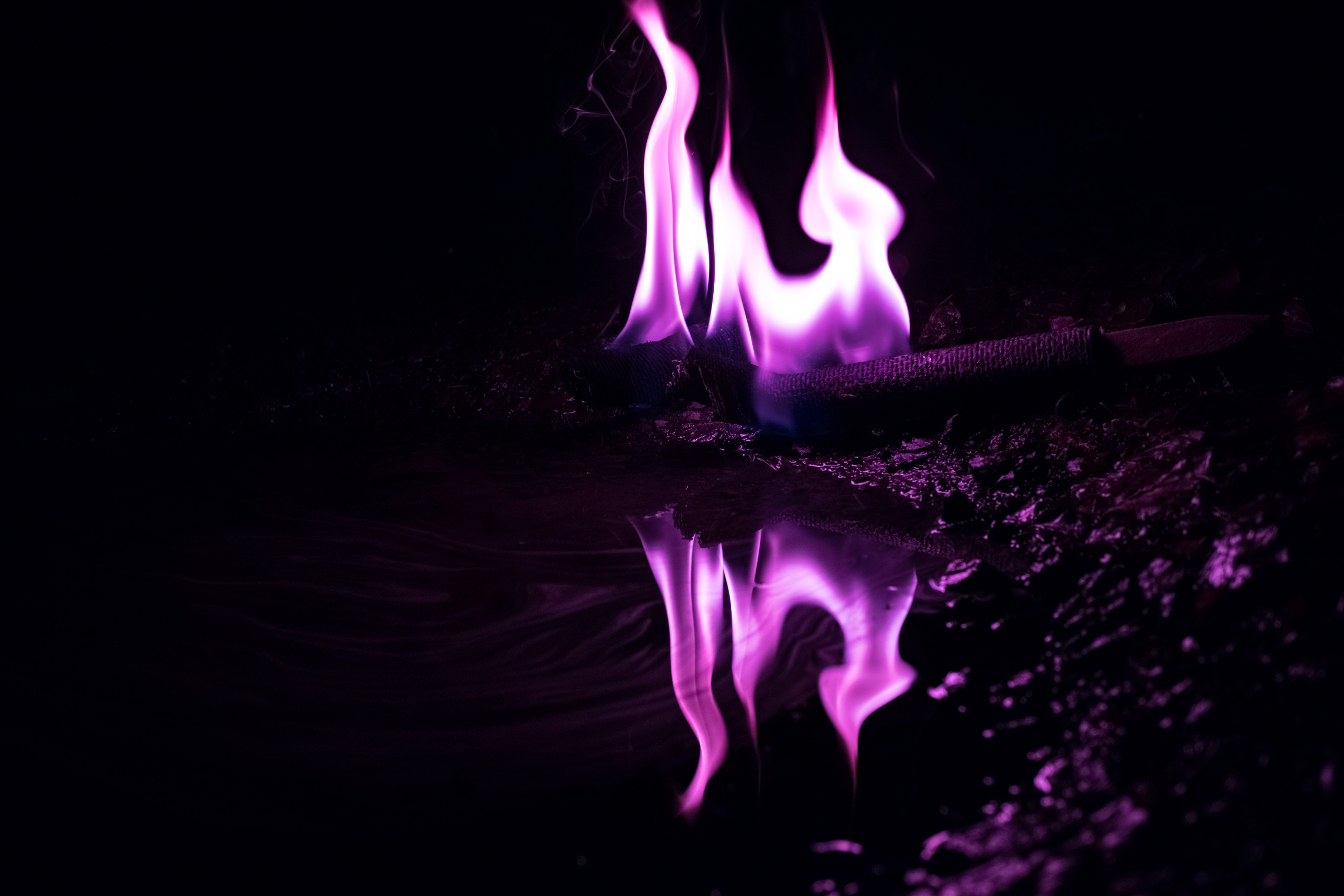 Purple fire reflecting on dark surface HD Wallpaper