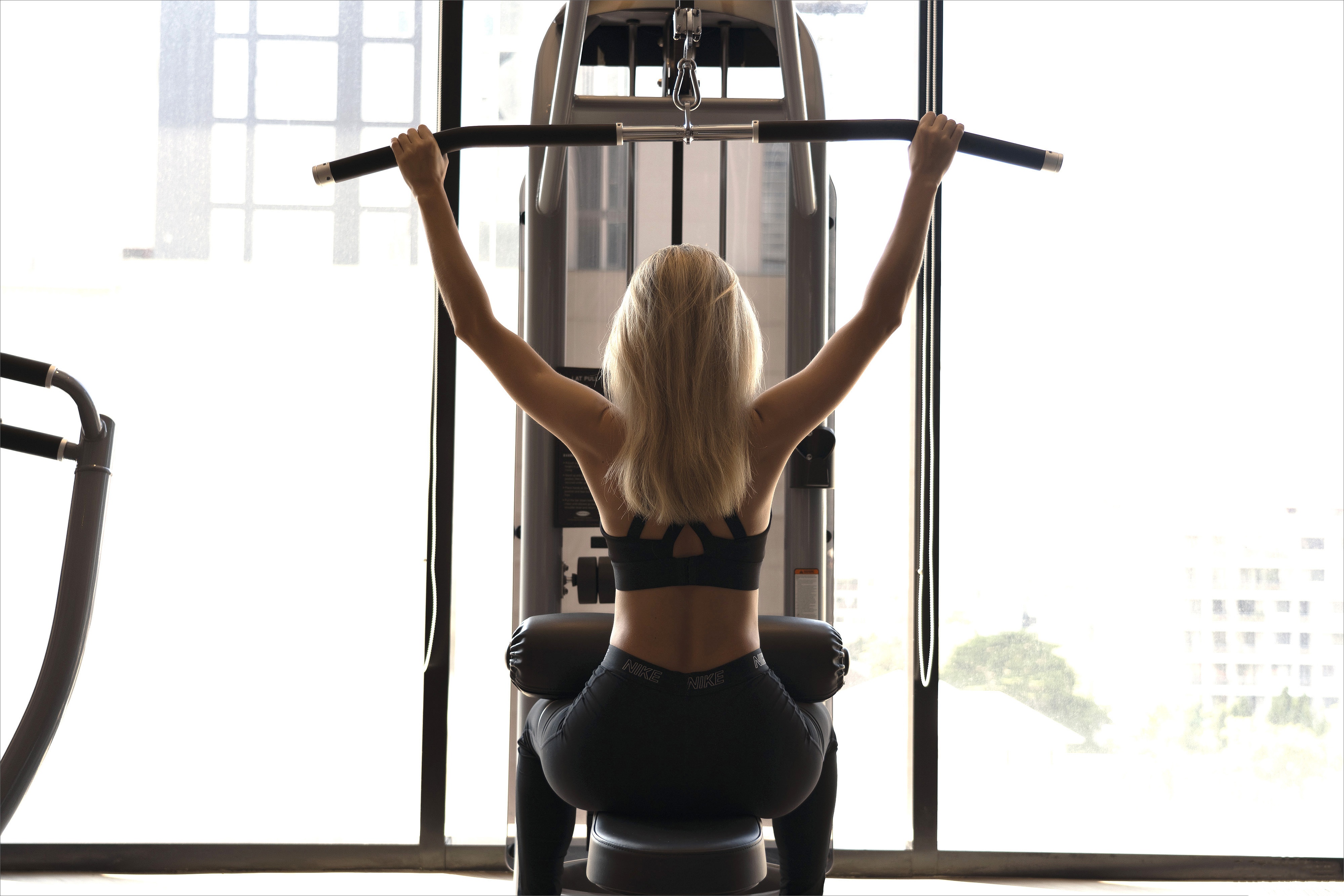 Woman exercising on a lat pulldown machine HD Wallpaper