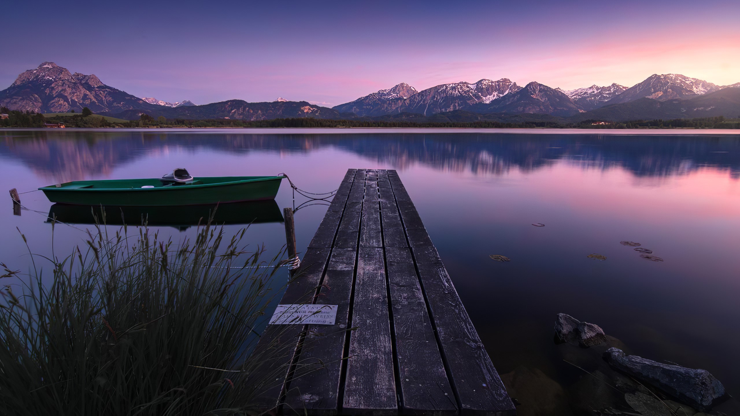 Boat on a calm lake with mountains at sunset HD Wallpaper