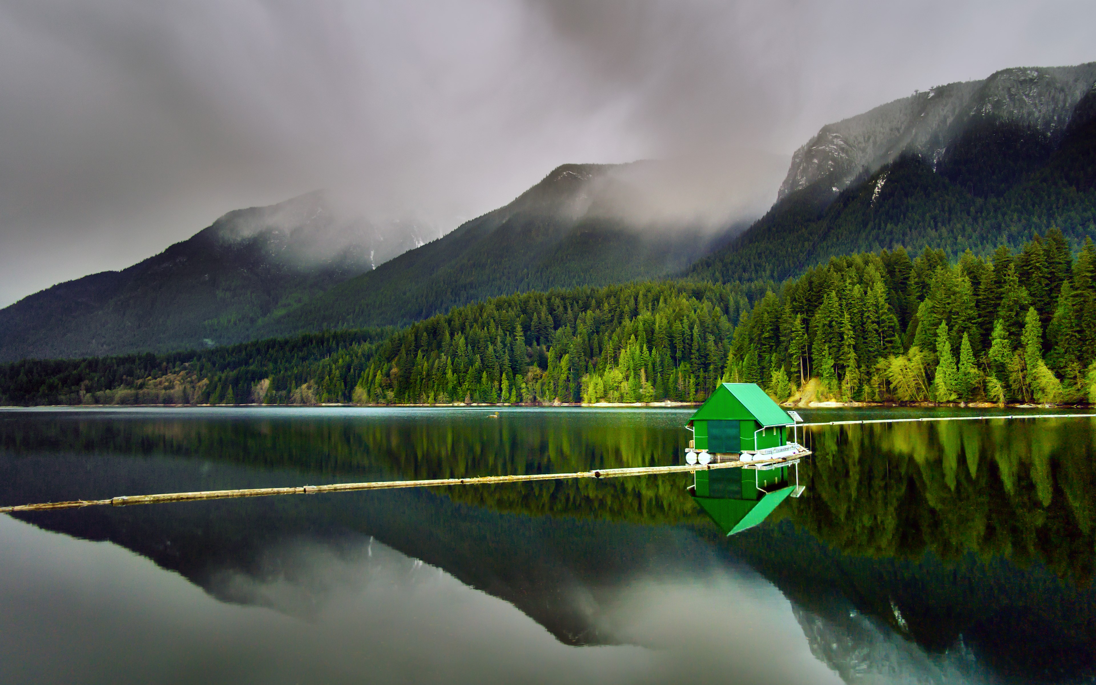 Green boathouse on a calm lake with mountains HD Wallpaper