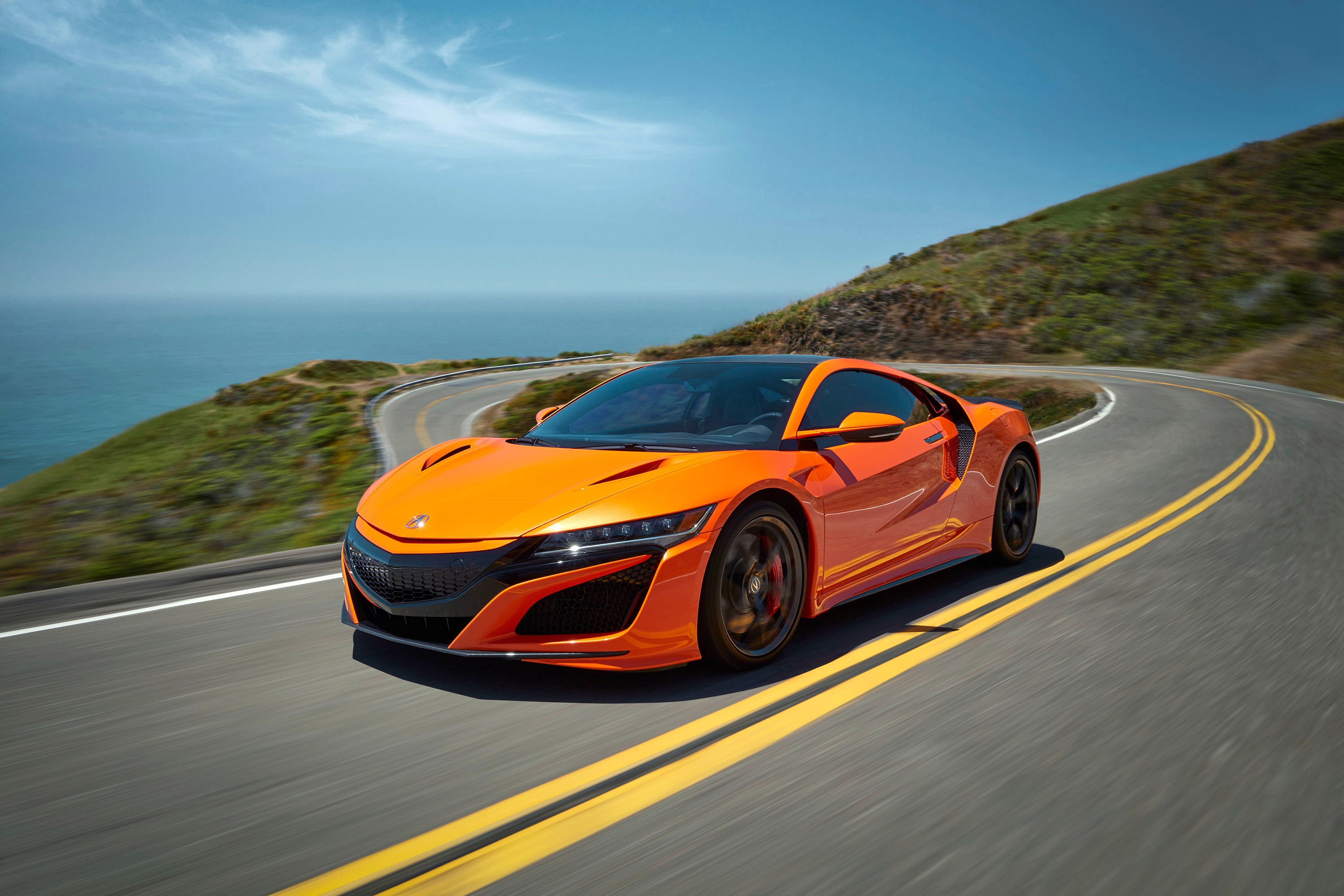 Orange Acura NSX driving on a coastal road HD Wallpaper