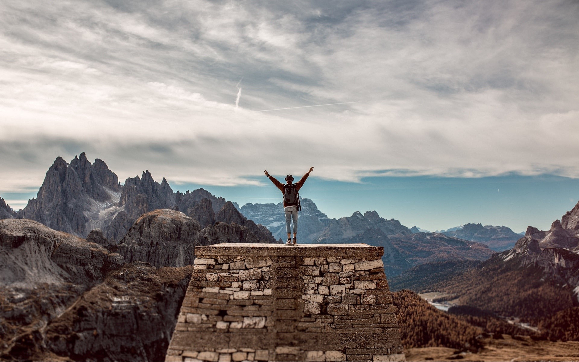 Person on stone platform with mountain range background HD Wallpaper