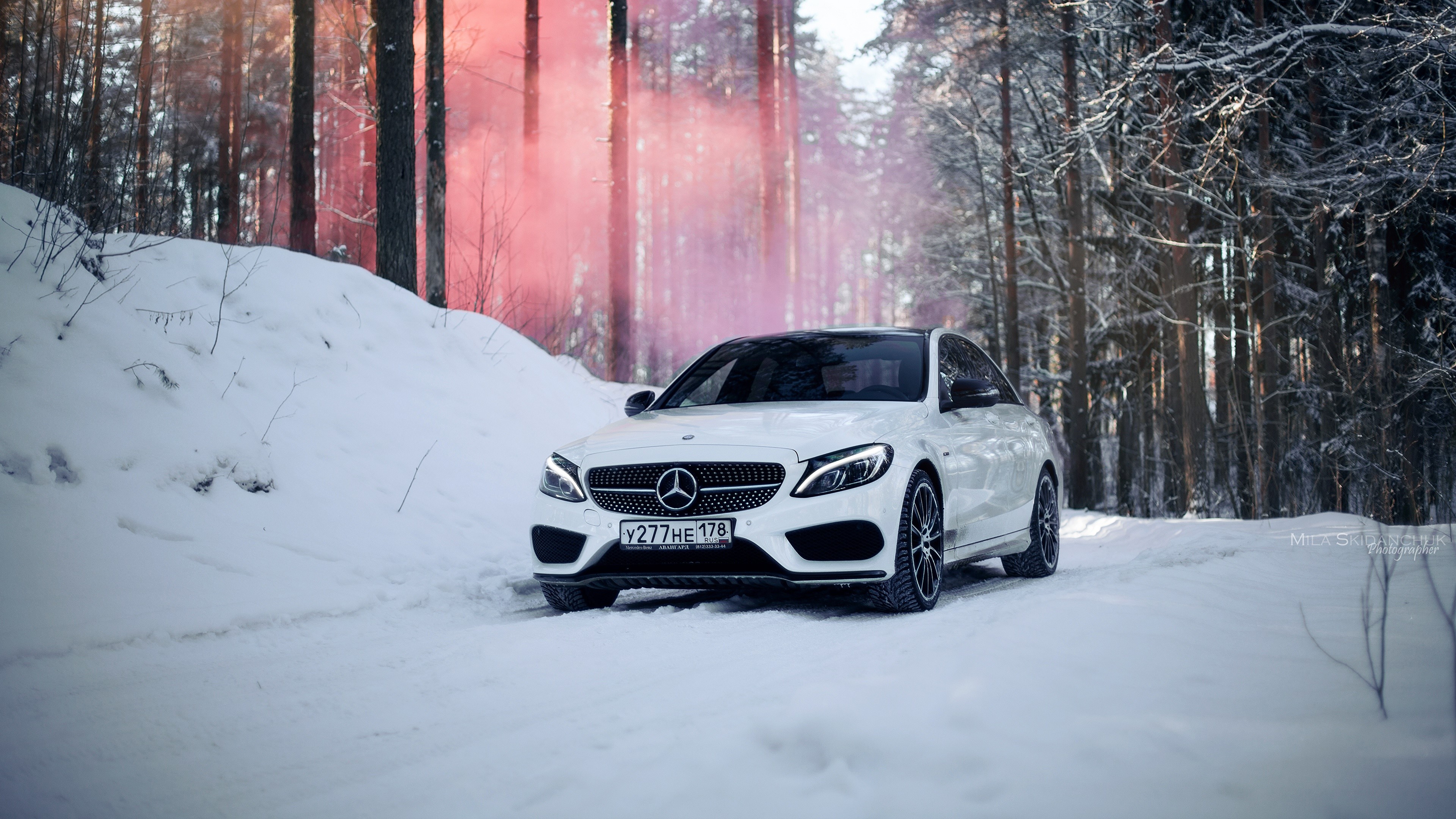 White Mercedes Benz C-Class in snowy forest with red smoke HD Wallpaper