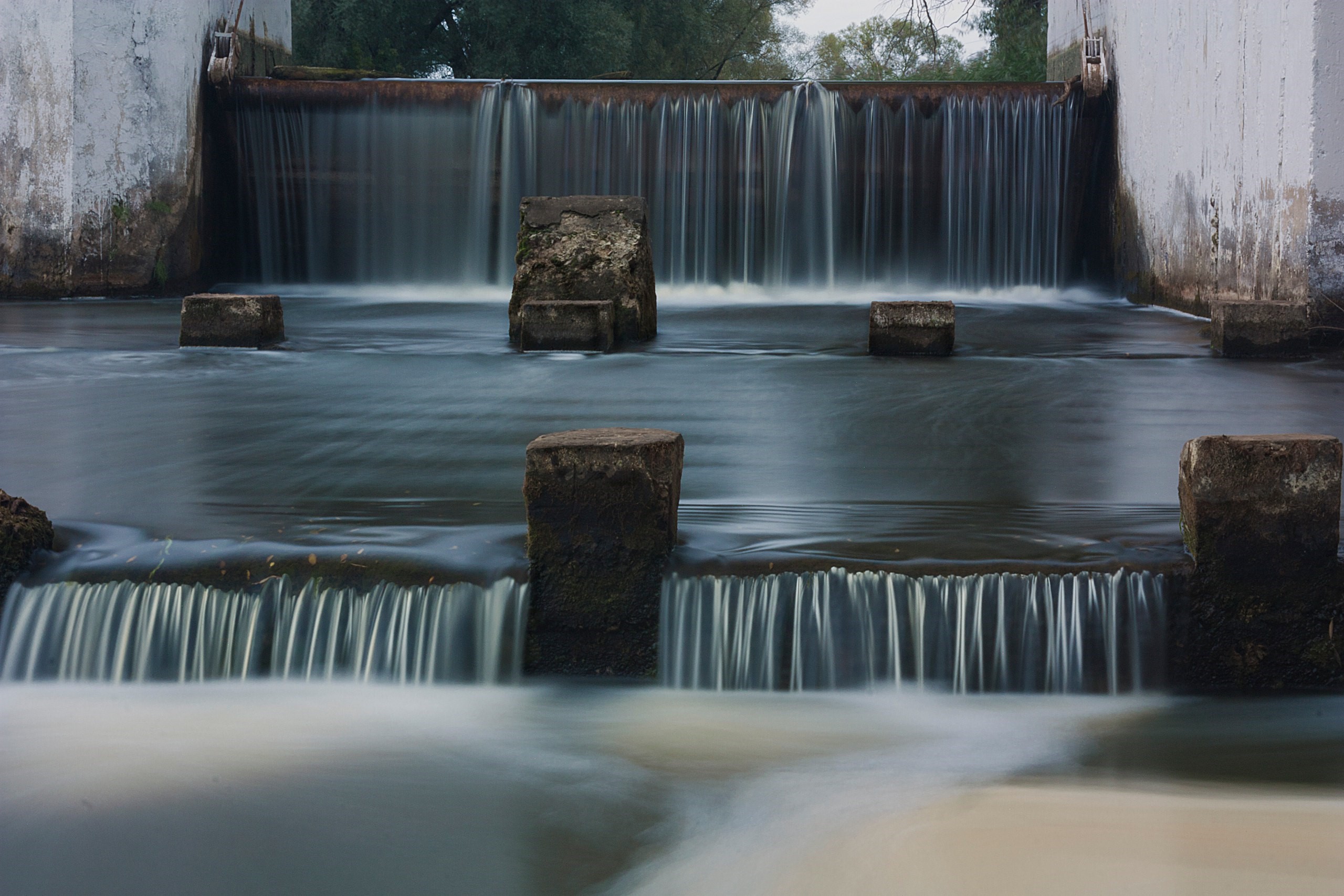 Waterfall cascading over concrete structure HD Wallpaper