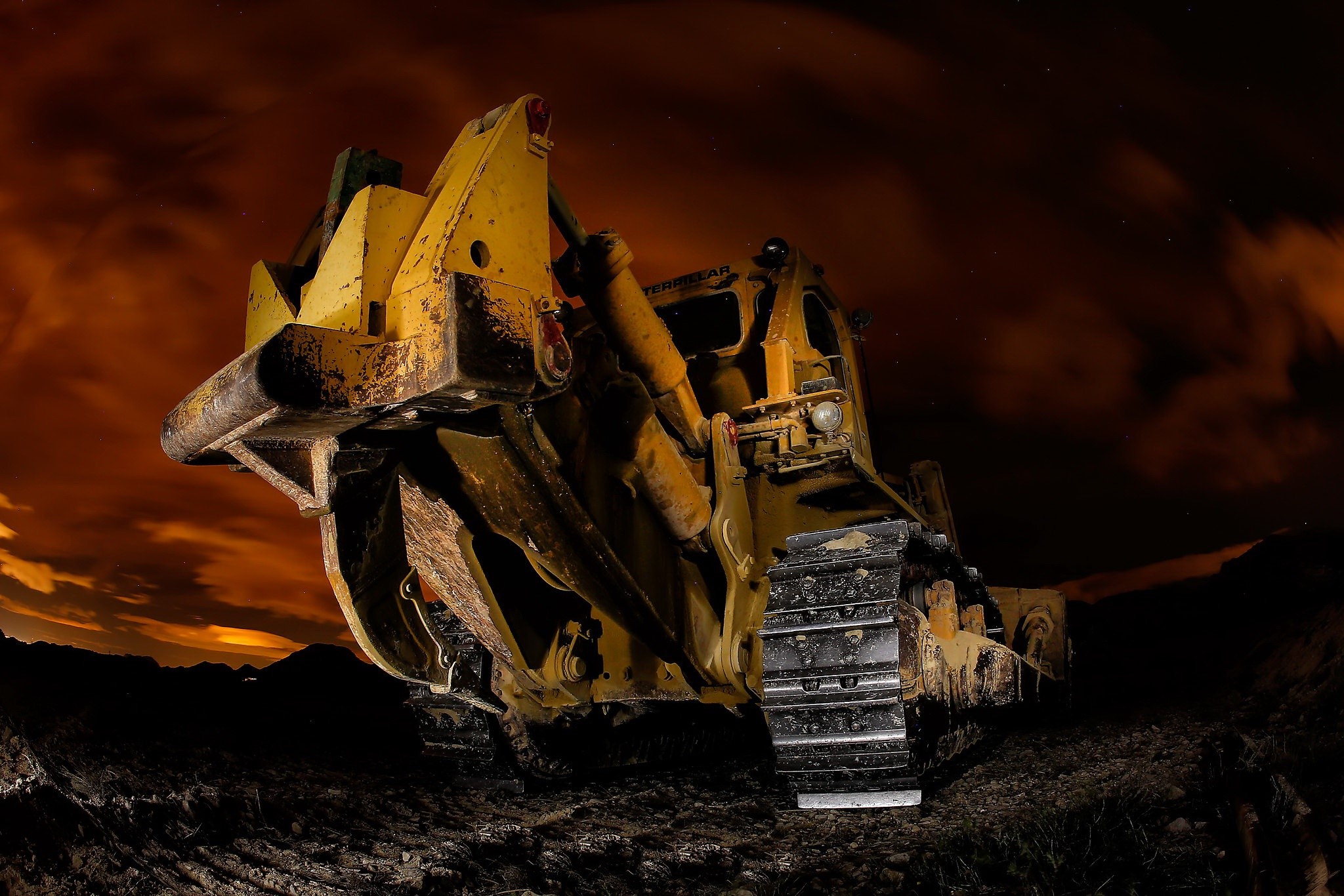 Yellow bulldozer at night with orange sky HD Wallpaper
