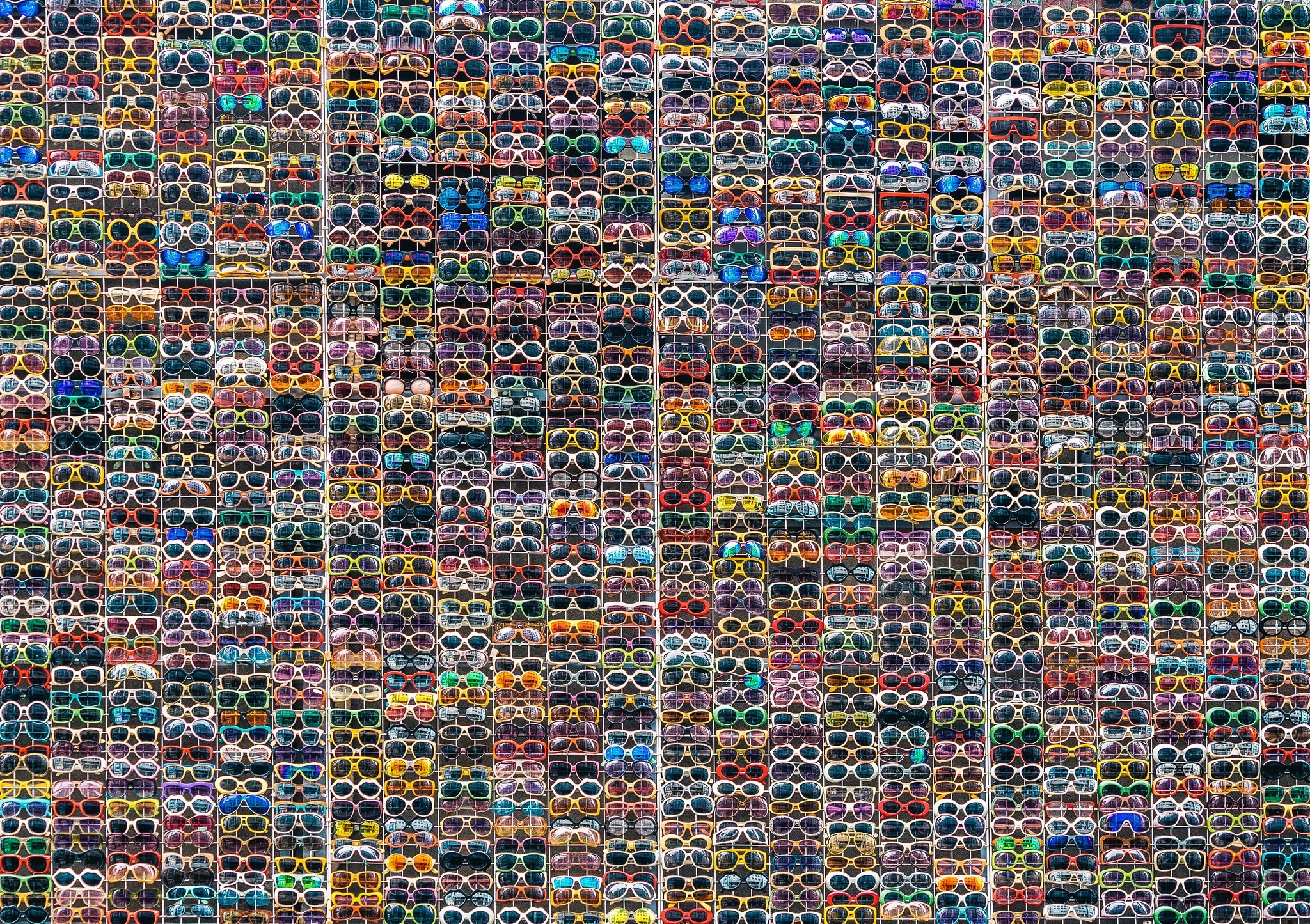 A large collection of colorful sunglasses displayed in a grid. HD Wallpaper