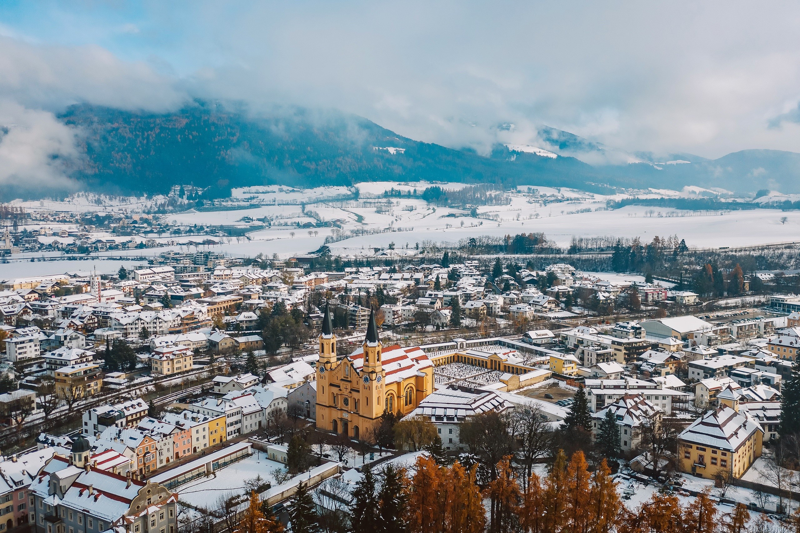 Winter town with church and snow-covered mountains HD Wallpaper