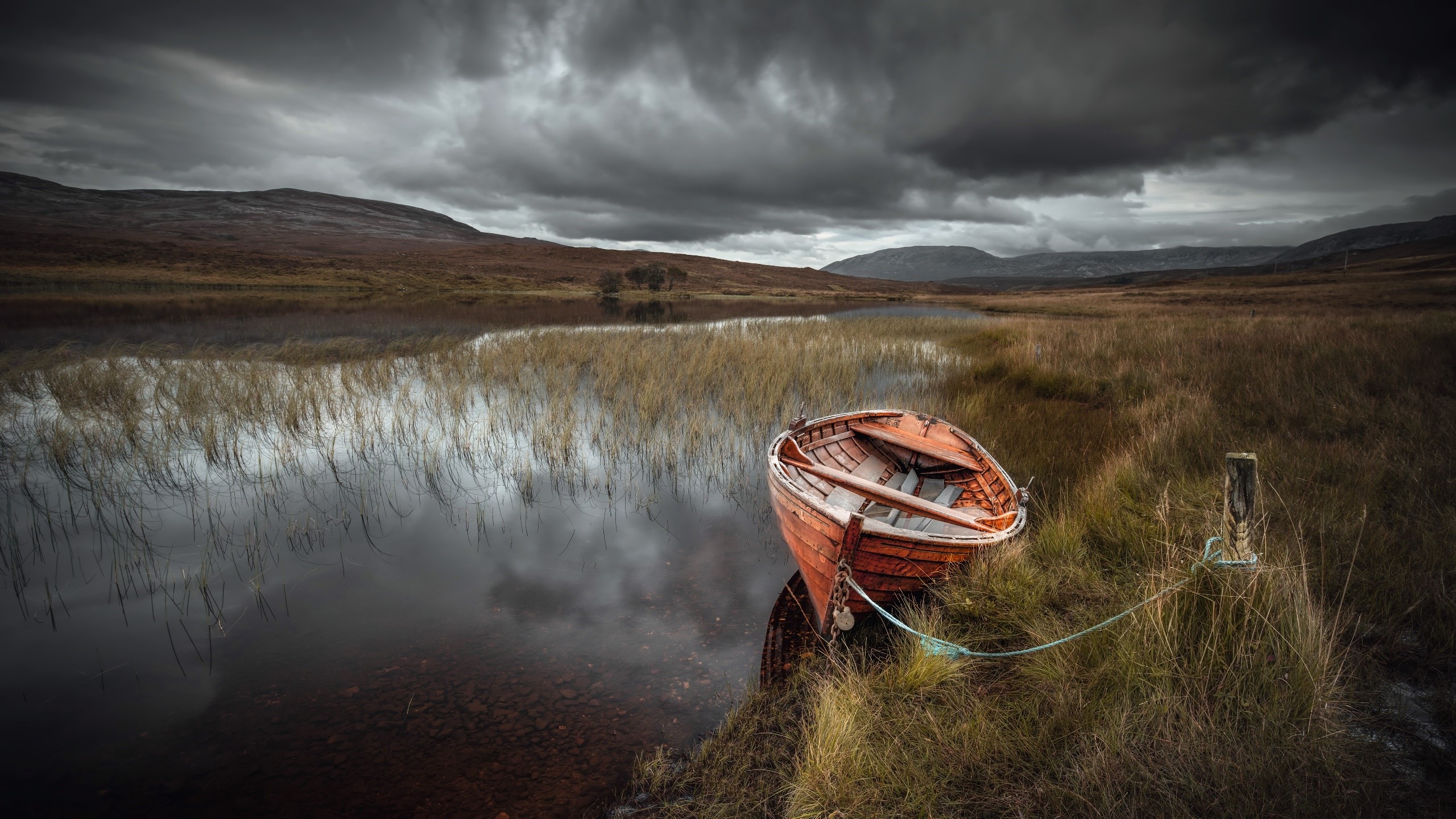 Orange rowboat on a lake with stormy clouds HD Wallpaper