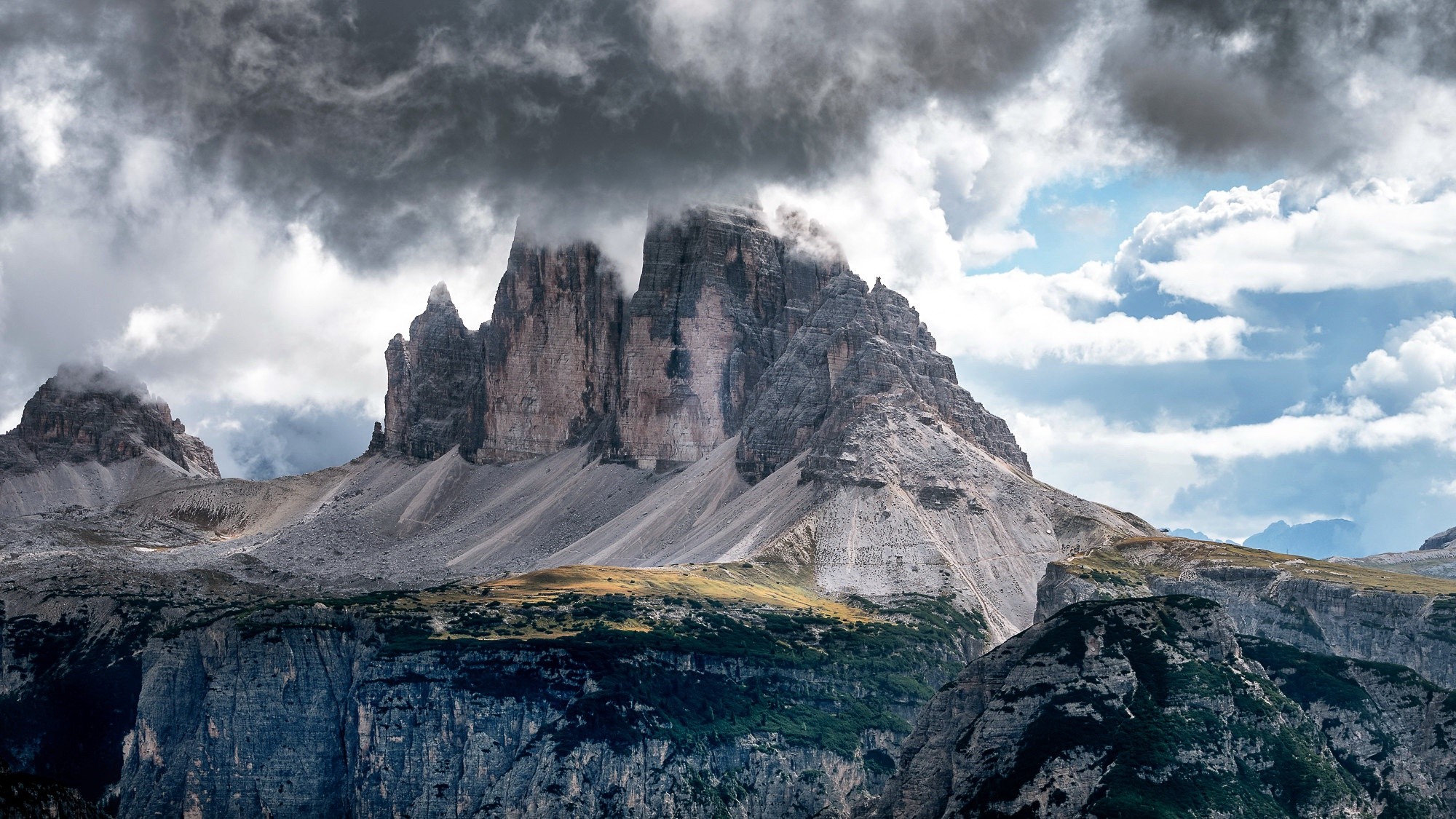 Tre Cime di Lavaredo mountains under dramatic clouds HD Wallpaper