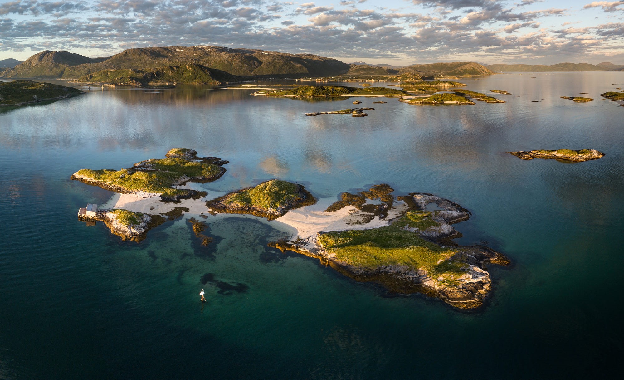 Islands in a calm bay with a person on a paddleboard HD Wallpaper