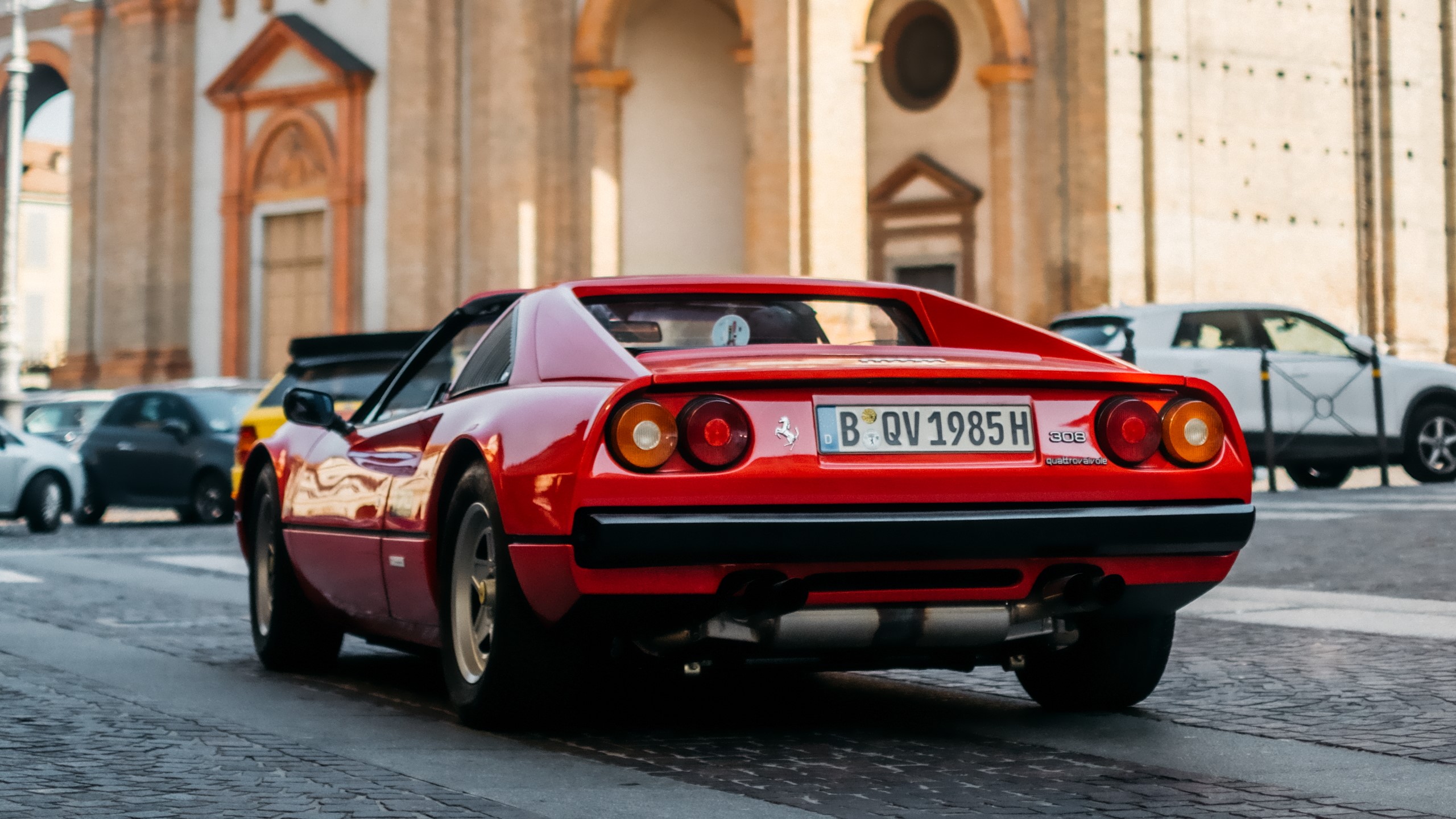 Red 1985 Ferrari 308 GTS parked in front of a building HD Wallpaper